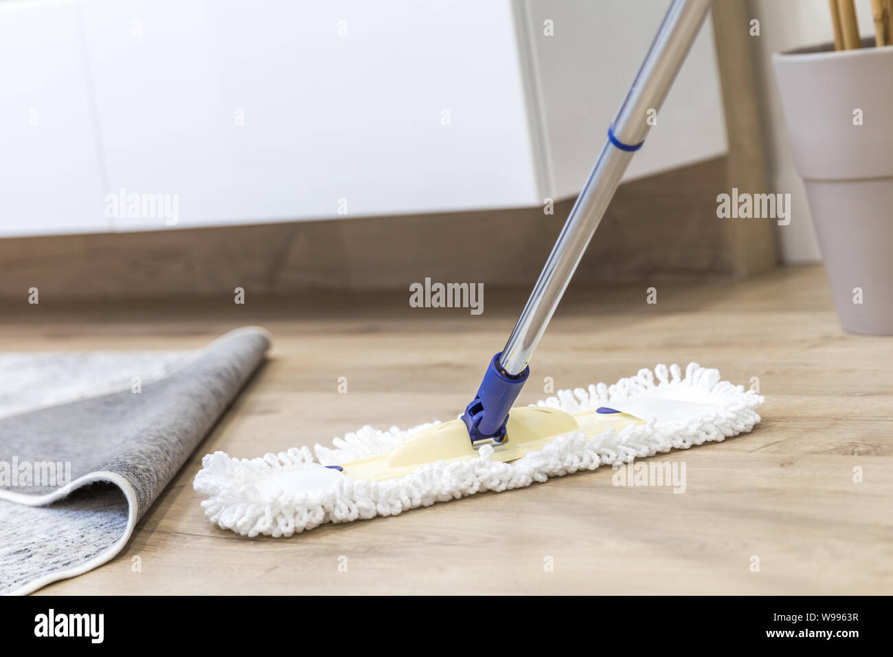 Modern white mop being used for cleaning a wooden floor Stock Photo Alamy