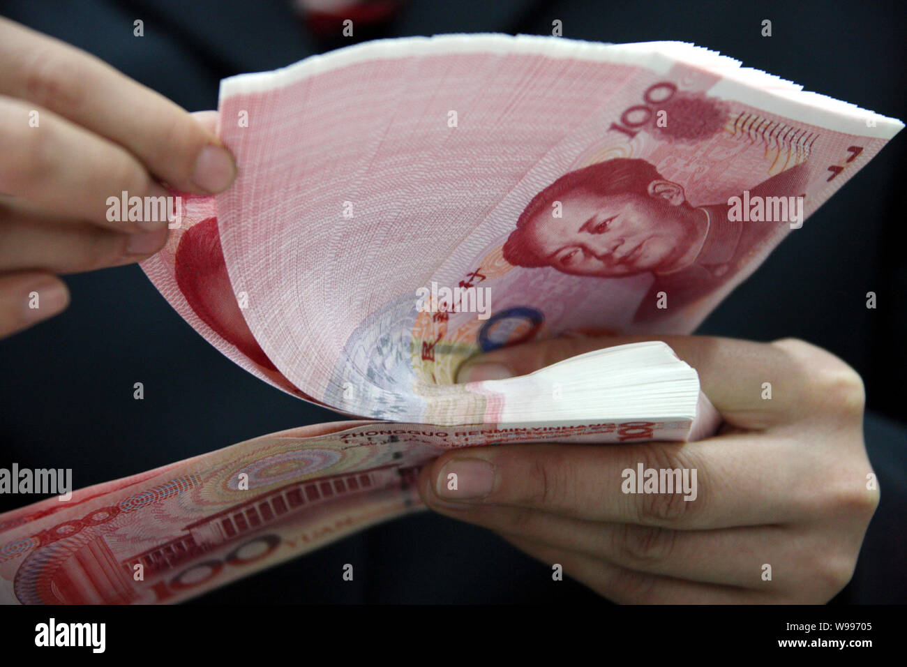 --FILE--A Chinese clerk counts RMB (renminbi) yuan bills at a bank in ...