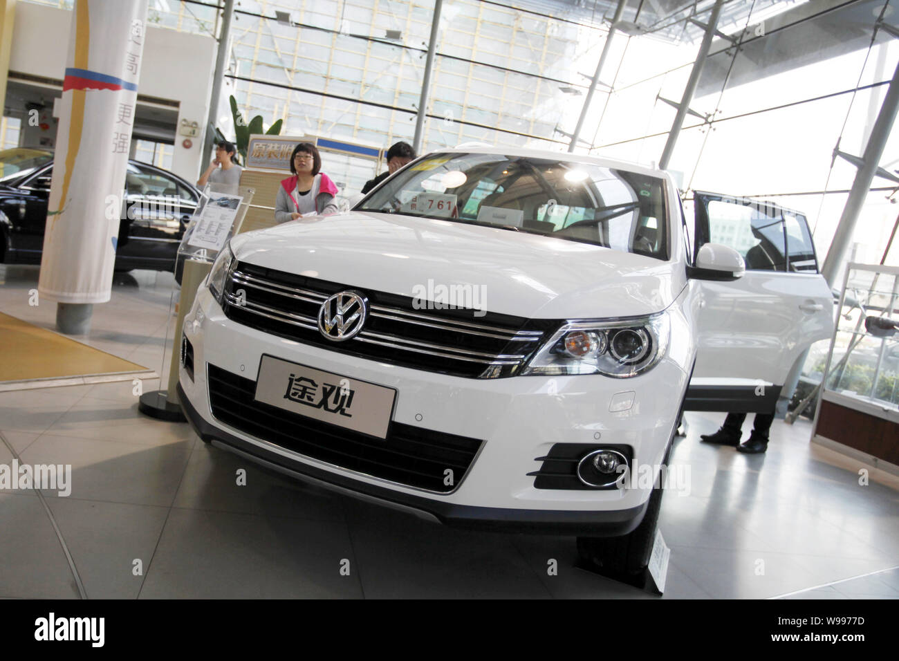 --FILE--Chinese car buyers look at a Volkswagen Tiguan at a dealership of Shanghai Volkswagen, a joint venture between SAIC and VW, in Shanghai, China Stock Photo