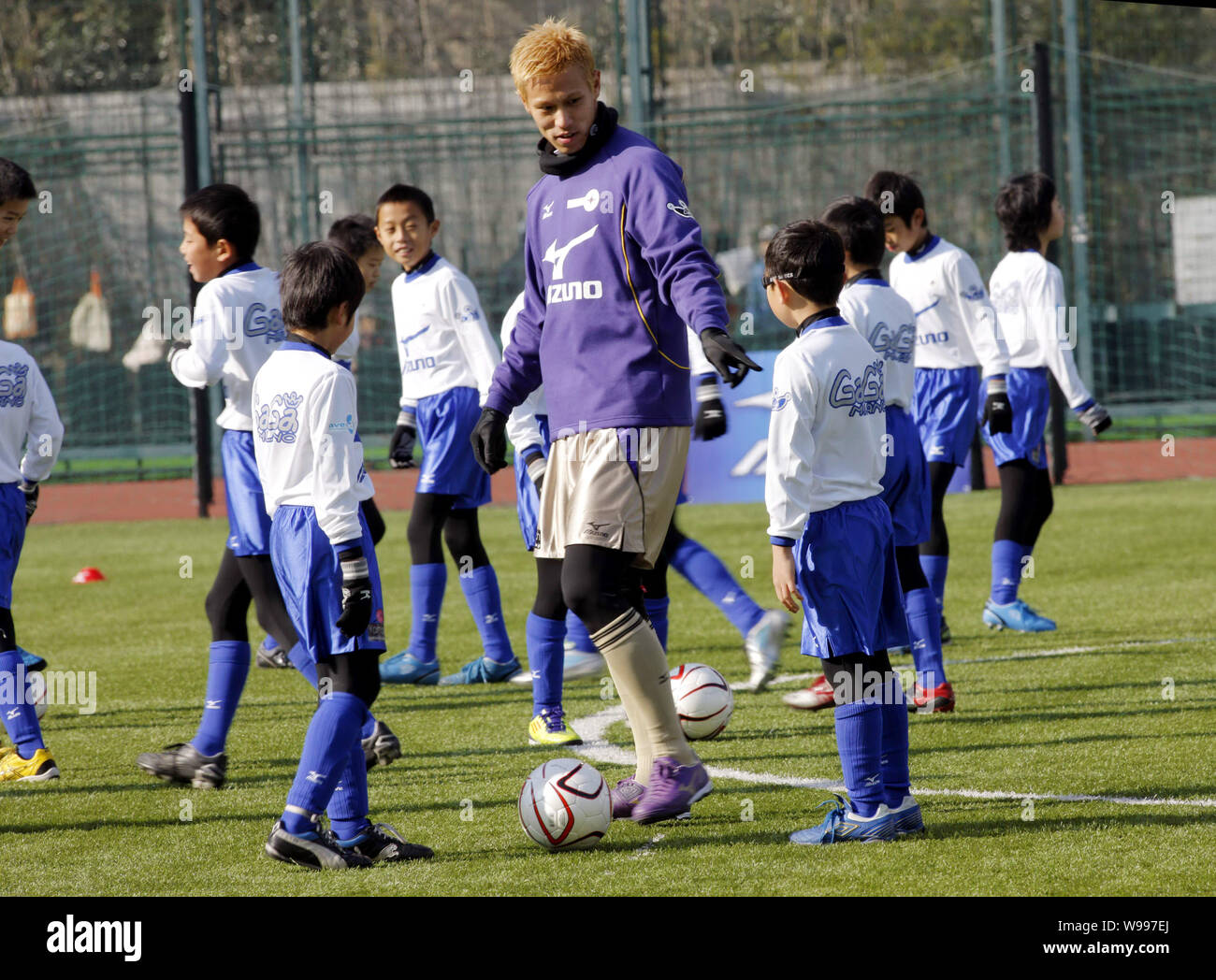 Japanese football player Keisuke Honda teaches young kids during the China-Japan Youth Football Exchange Programme in Shanghai, China, 17 December 201 Stock Photo