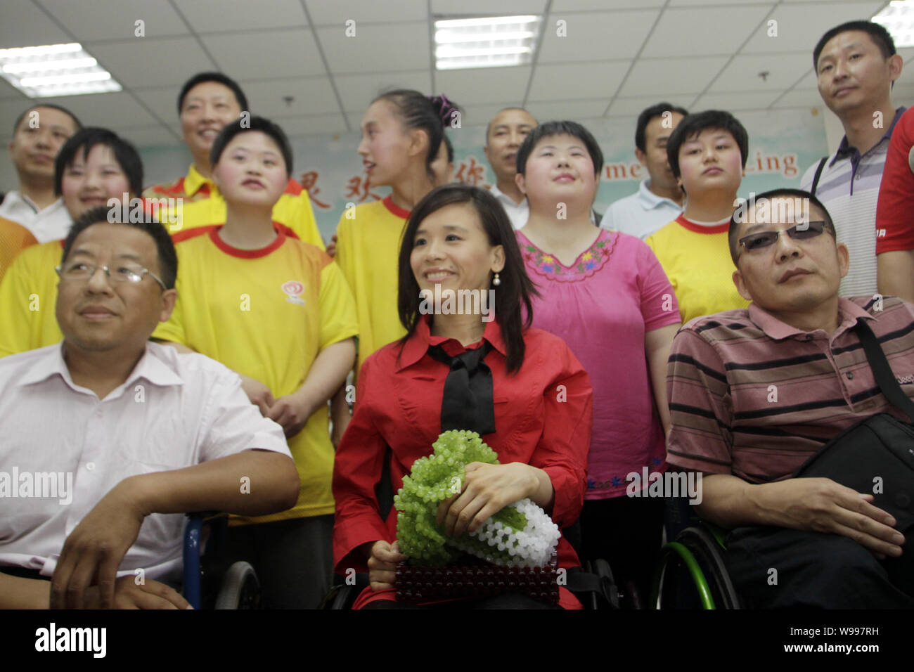 Chinese paralyzed gymnast Sang Lan, front center, visits a local