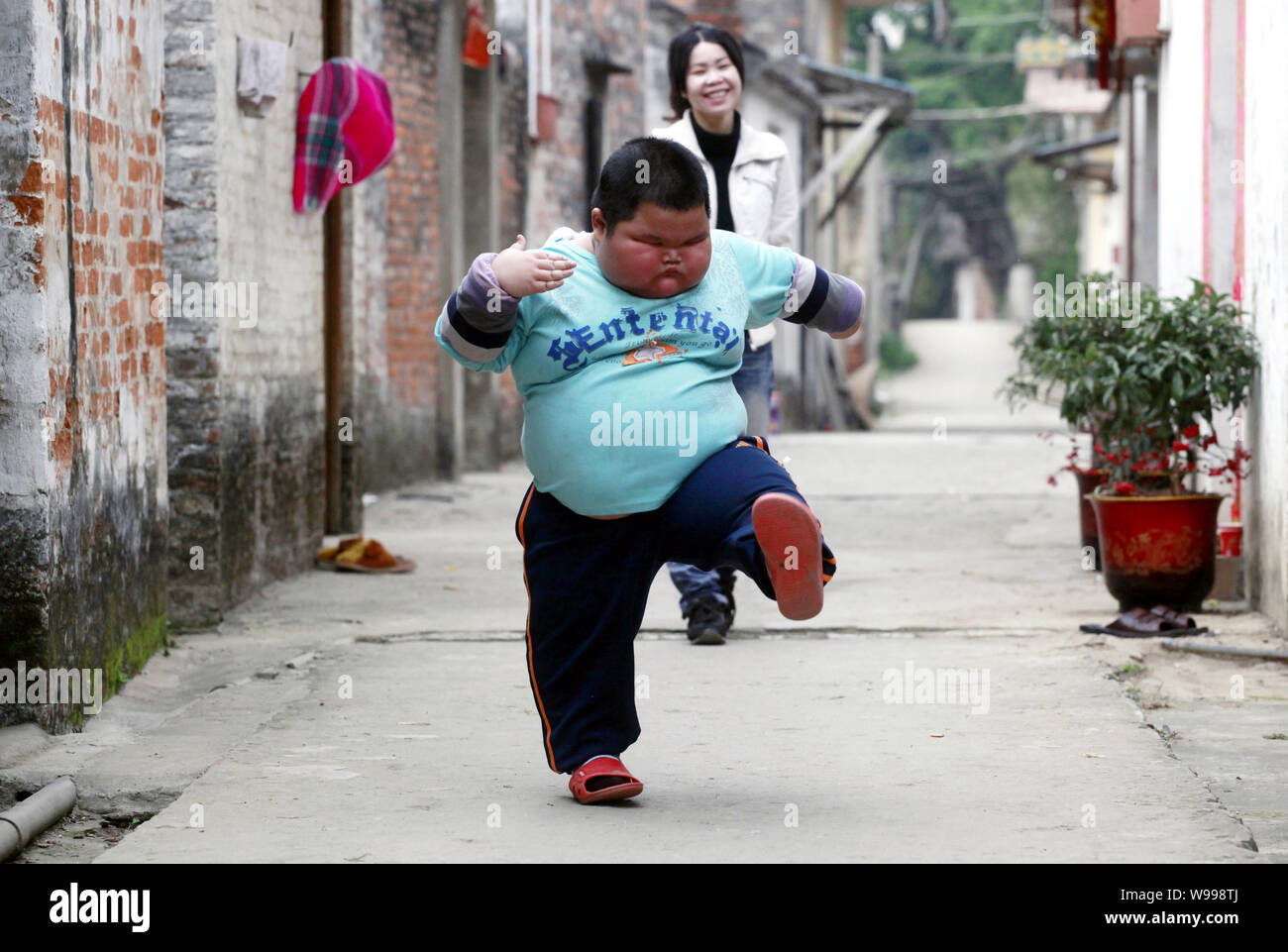 The fattest child, Lu Zhihao, walks with his mother in Foshan, southeast Chinas Guangdong Province, 29 March 2011.   Lu Zhihao is an obese child haili Stock Photo