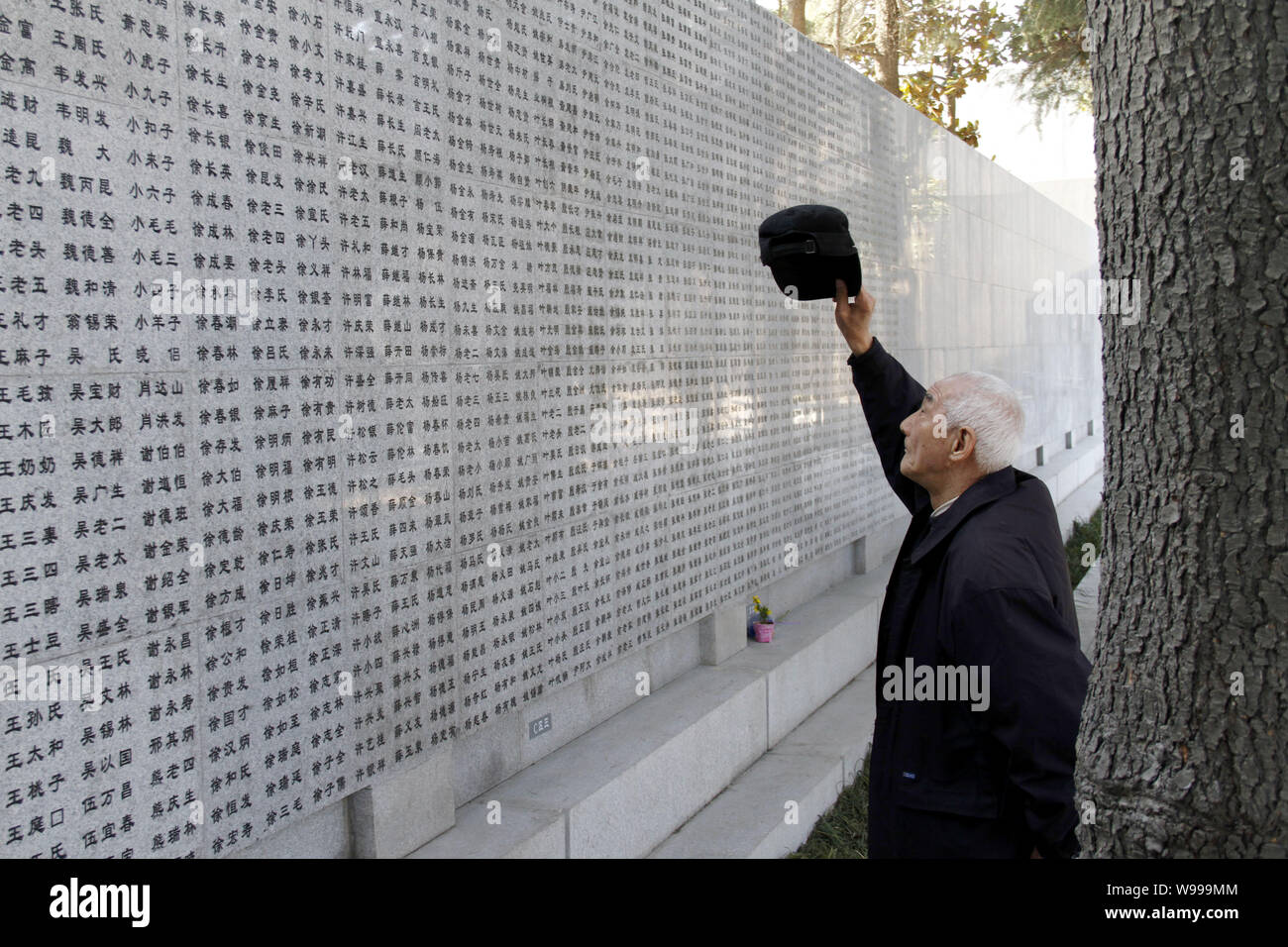 Nanjing Massacre survivor Xu Qingen, 79, looks for the name of his brother Xu Qingrong among the newly-carved victims names on the Wailing Wall of the Stock Photo
