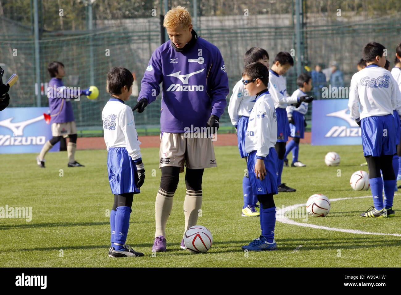Japanese football player Keisuke Honda teaches young kids during the China-Japan Youth Football Exchange Programme in Shanghai, China, 17 December 201 Stock Photo