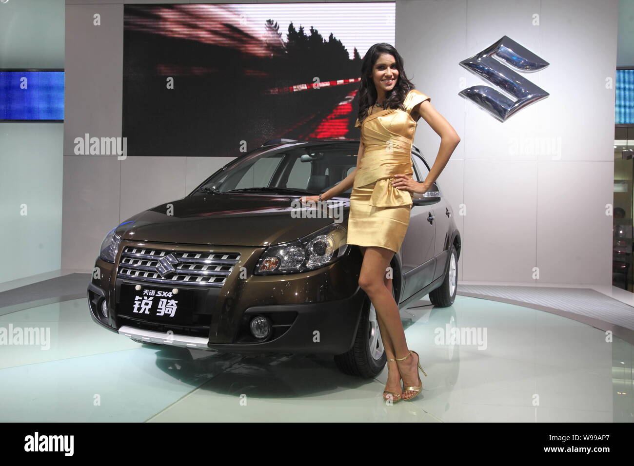 A model poses by a Suzuki SX4 during the 9th China (Guangzhou) International Automobile Exhibition, known as Auto Guangzhou 2011, in Guangzhou city, s Stock Photo
