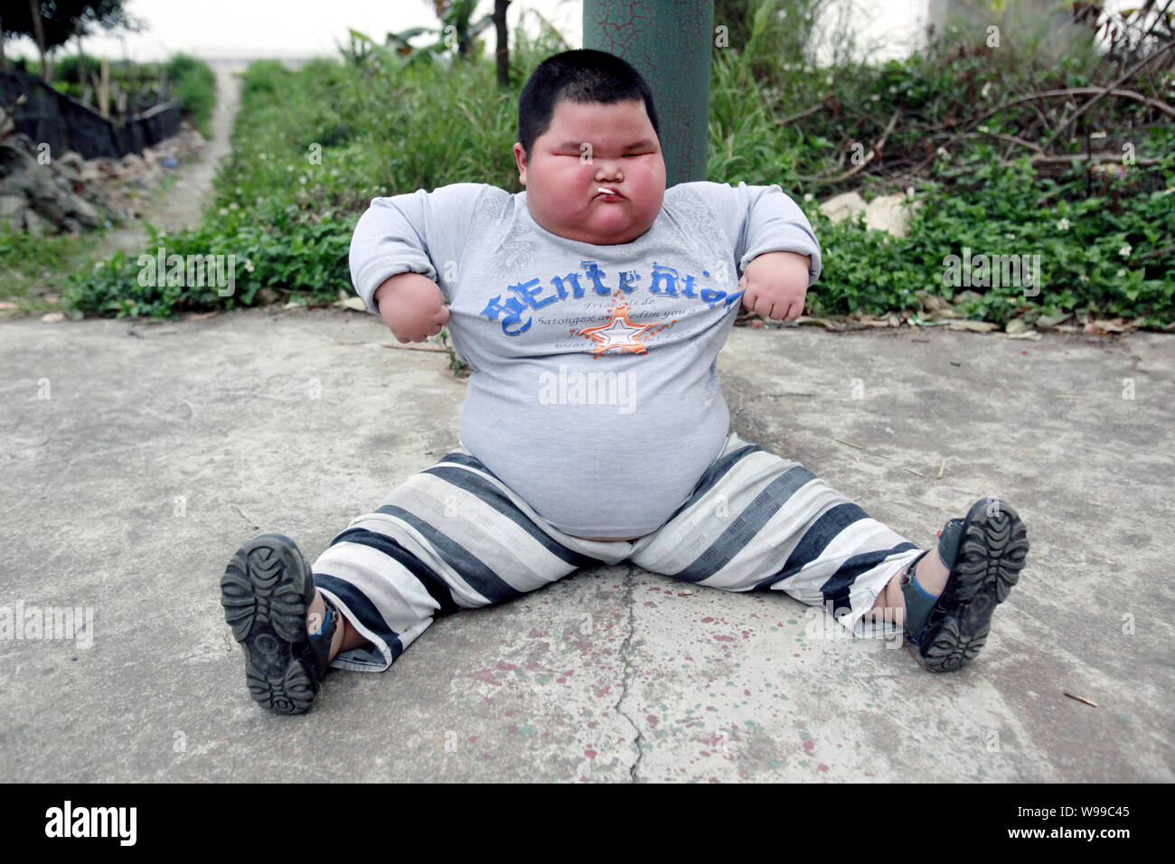 The fattest child, Lu Zhihao, sits on the ground to take a rest in Foshan, southeast Chinas Guangdong Province, 28 March 2011.   Lu Zhihao is an obese Stock Photo