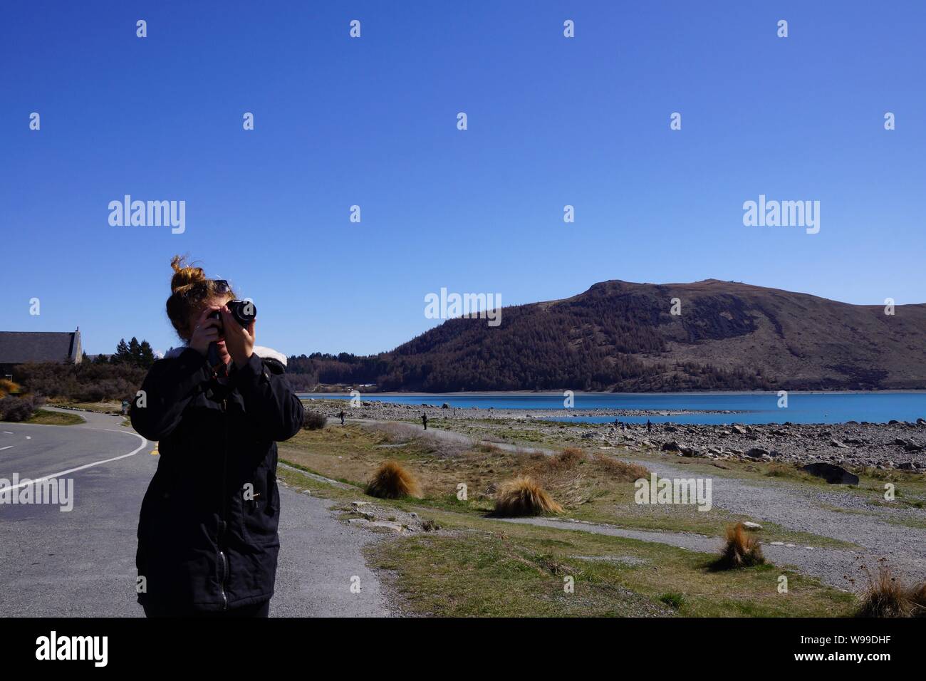 Young female photographer readying herself to take photo. Stock Photo