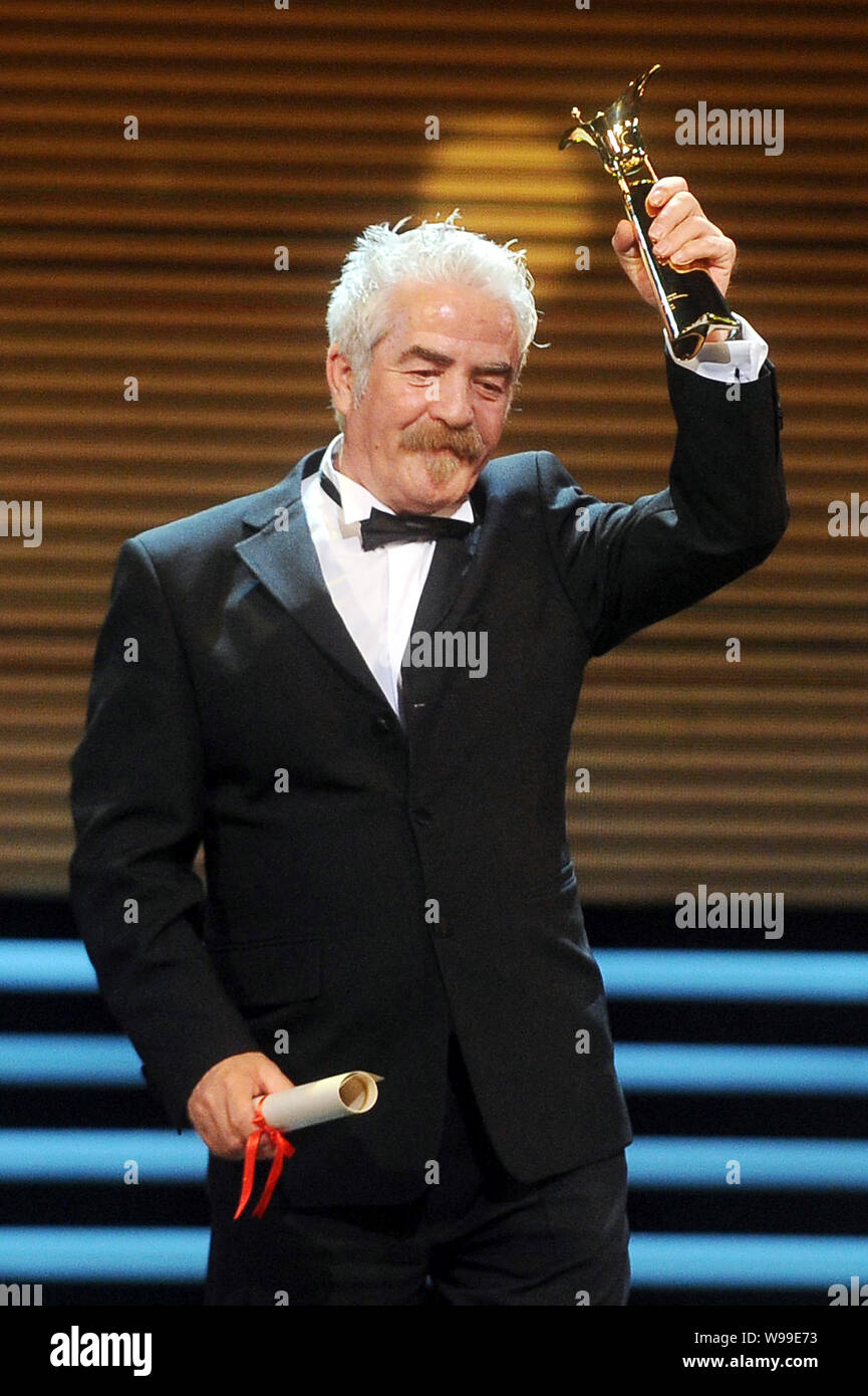 Macedonian actor Sevket Emrulla holds up his trophy for the Best