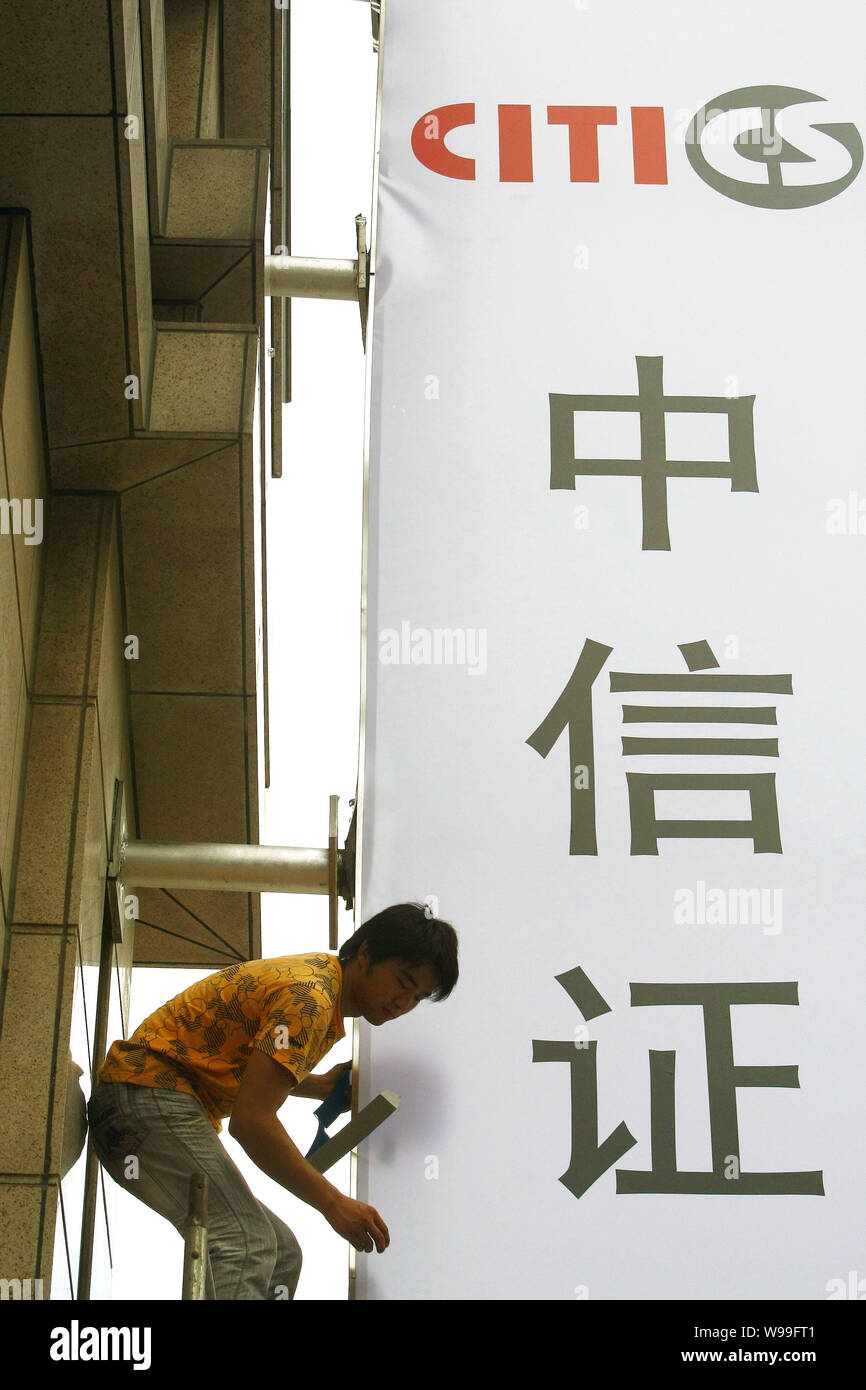 --File--A man is fixing the signage of CITIC (China International Trust and Investment Corporation) Securities in Shanghai, China, 2 September 2010. Stock Photo