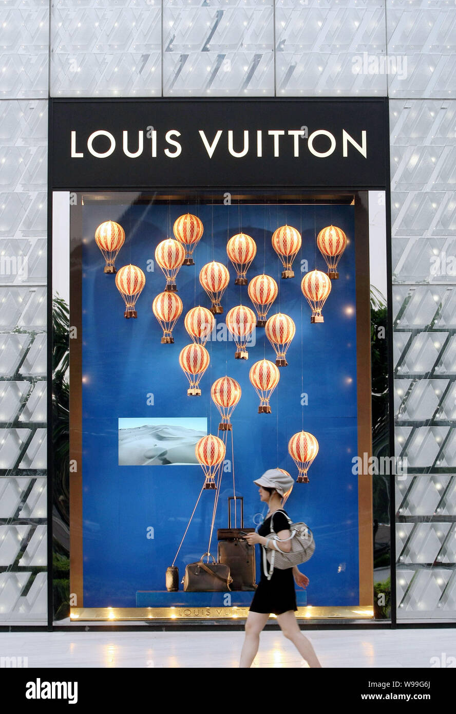 A trendy young woman walks the Louis Vuitton (LV) at the International Finance Center (IFC) in the Lujiazui Financial in Pudong Stock Photo - Alamy