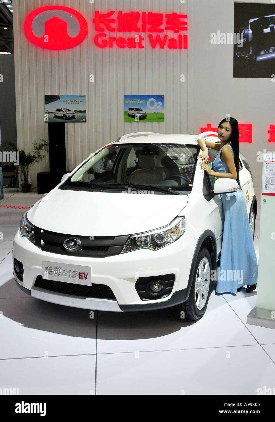 --FILE--A model poses next to the Hover M3 EV of Great Wall Motor during a fair in Shenzhen city, south Chinas Guangdong province, 8 November 2010. Stock Photo
