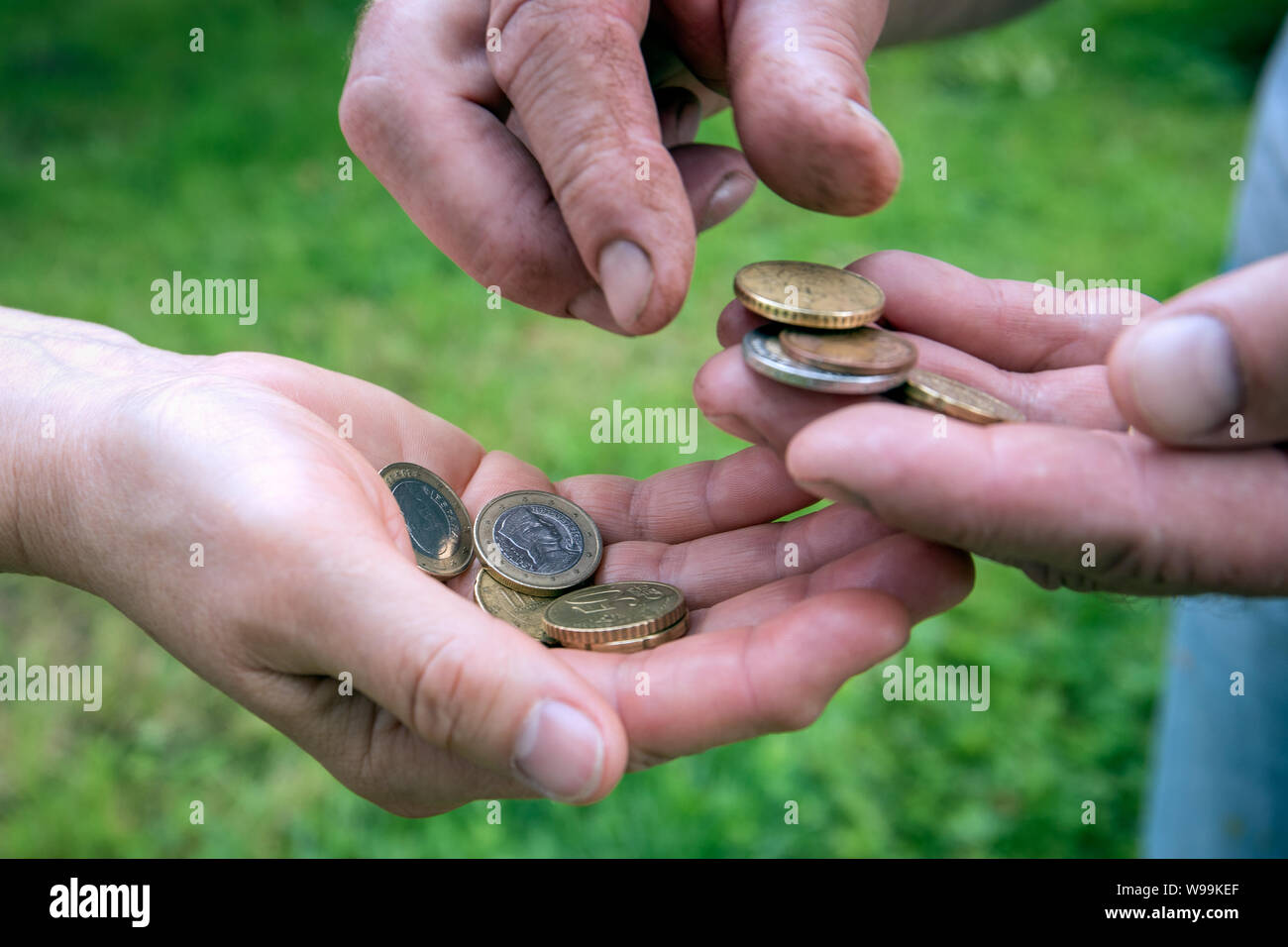 Euro coins in hands of two old man. Counting and sharing money Stock