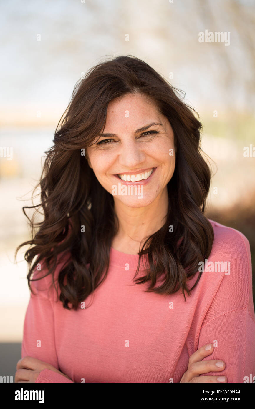 Beautiful mature middle age woman smiling outside Stock Photo - Alamy