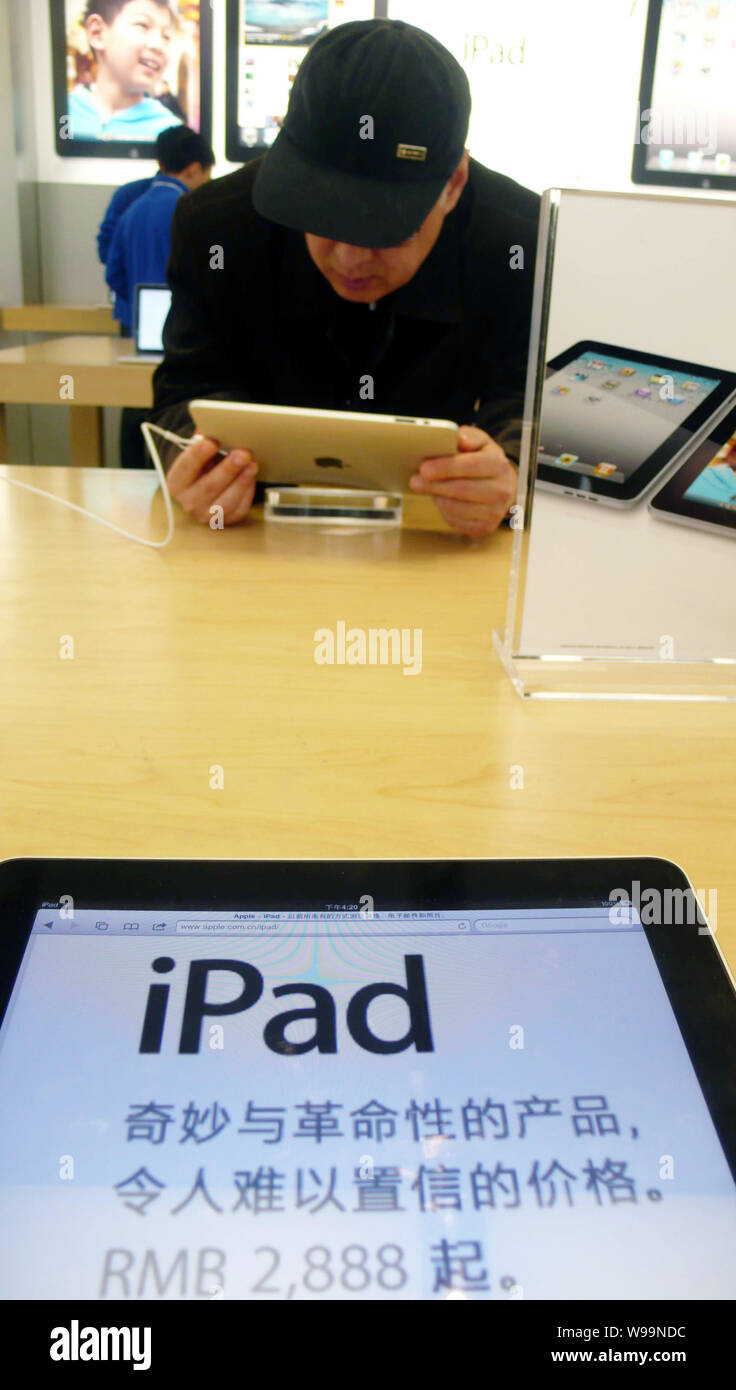 FILE--A shoppers tries out the iPad tablet PC in an Apple Store in  Shanghai, China, 3 March 2011. Apples iPad 2 is expected to go on sale on  the C Stock Photo - Alamy