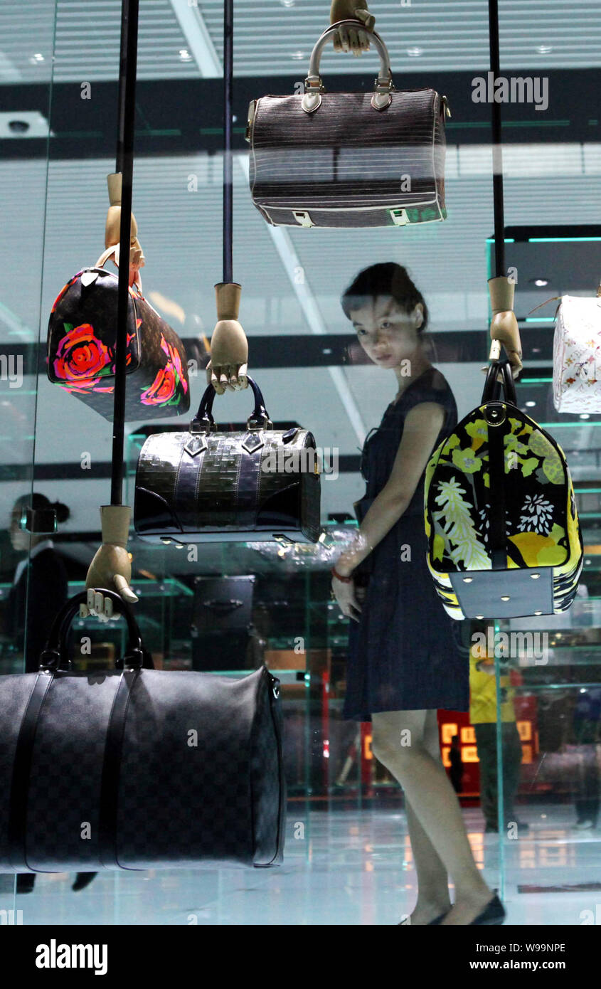A visitor looks at handbags on display during the Louis Vuitton Voyages  exhibition at the National Museum of China in Beijing, China, 31 May 2011.  A Stock Photo - Alamy