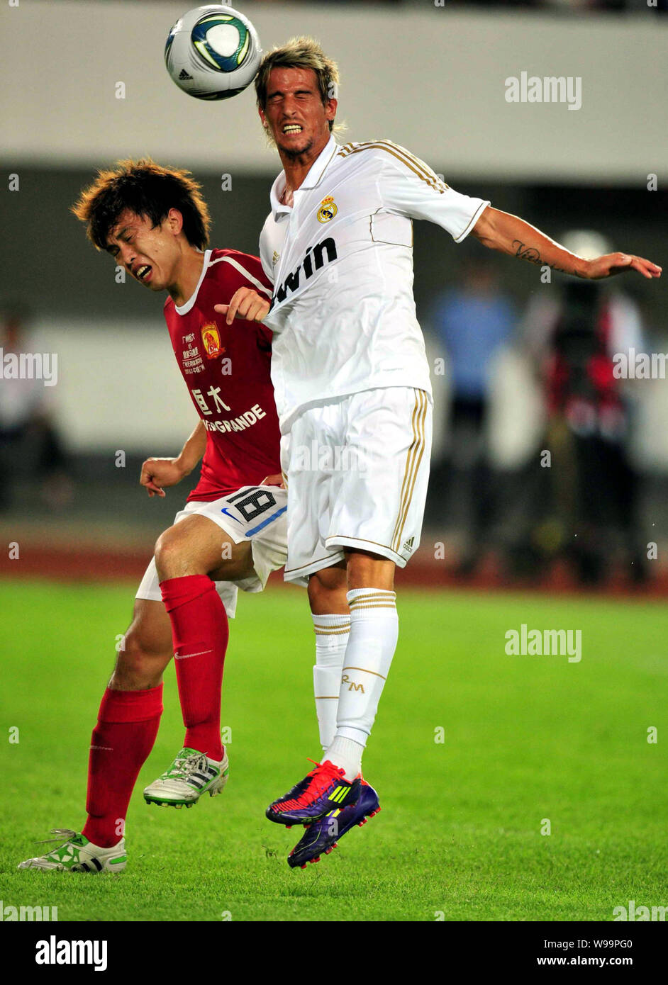 Fabio Coentrao of Real Madrid, right, challenges Chen Jianlong of Guangzhou Evergrande in a friendly soccer match in Guangzhou city, south Chinas Guan Stock Photo