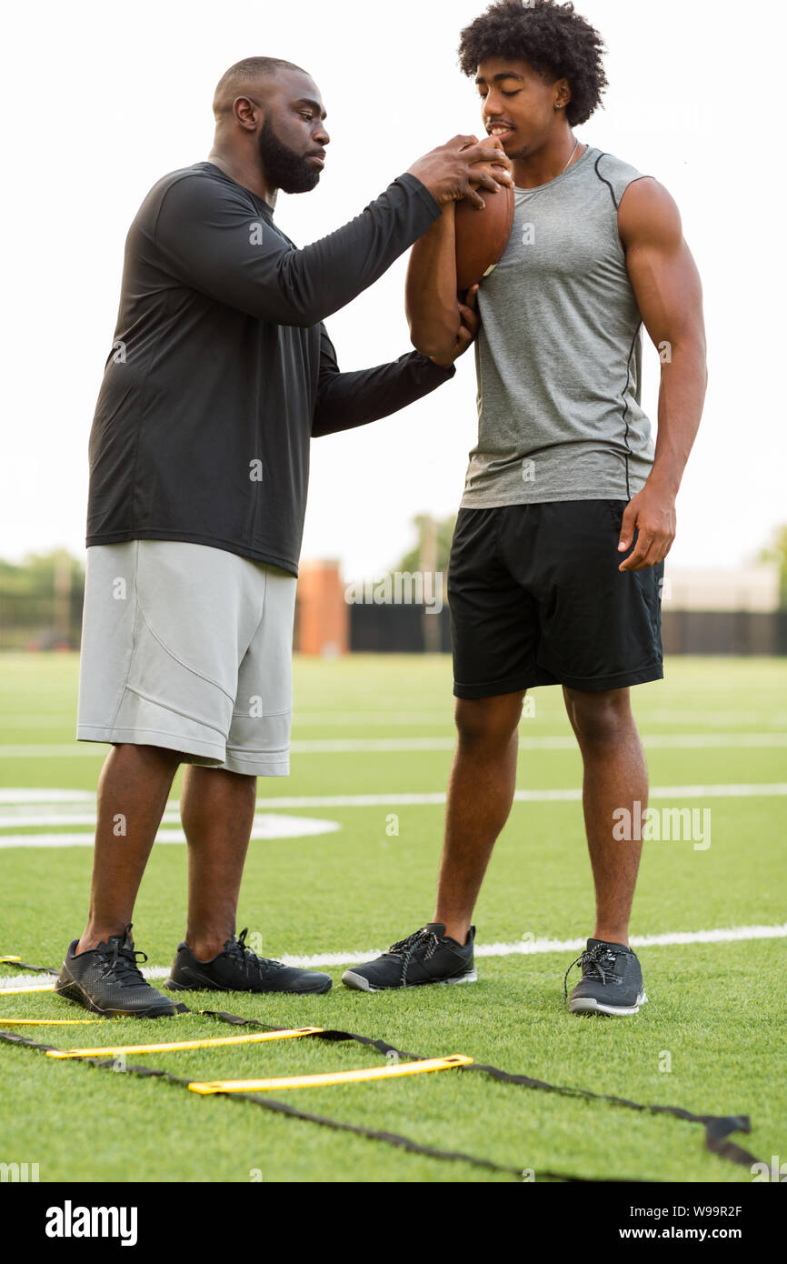 American Football coach training a young athlete Stock Photo - Alamy