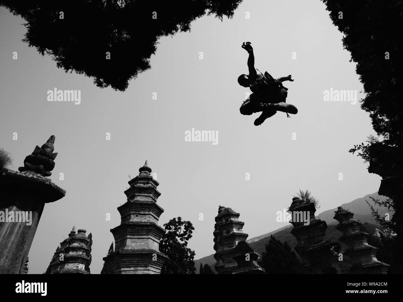 A young Shaolin monk practises kungfu at the Shaolin Temple in Dengfeng city, central Chinas Henan province, 15 August 2009. Stock Photo