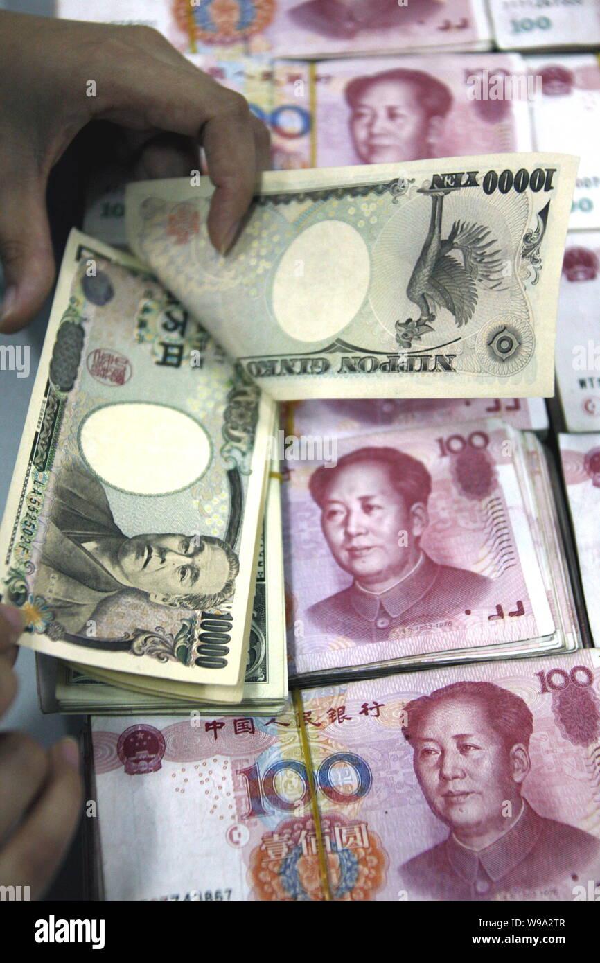 A Chinese bank clerk counts Japanese Yan banknotes over RMB (renminbi) yuan  banknotes at a bank in Huaibei city, east Chinas Anhui province, August 17  Stock Photo - Alamy