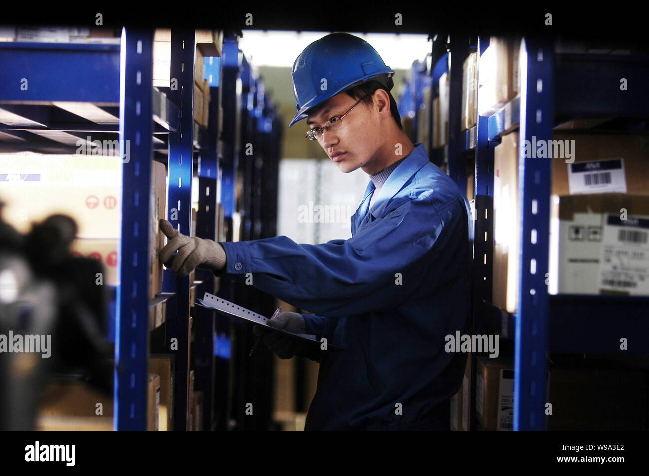 --FILE--A Chinese worker checks packages in the warehouse of Tianjin Binhai Teda Logistics (Group) Co., Ltd. in Tianjin, China, 25 November 2007.   Th Stock Photo