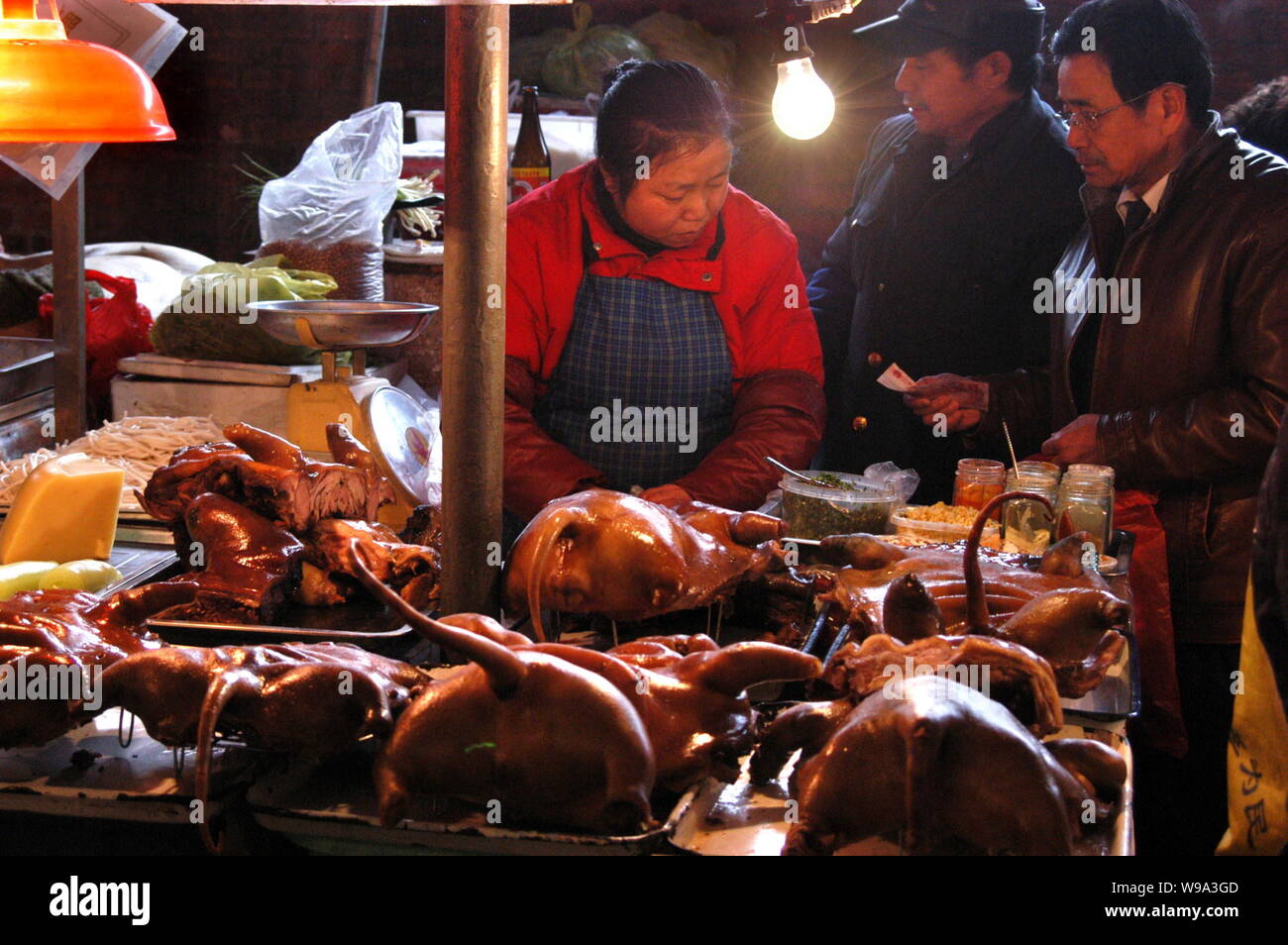 --FILE--A Chinese vendor sells dog meat to customers at a food market in Guiyang city, southwest Chinas Guizhou province, 20 December 2009.   A propos Stock Photo