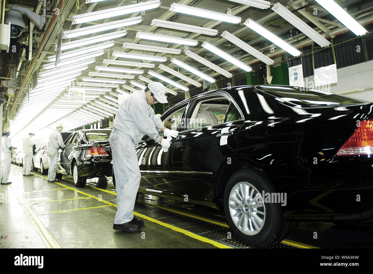 --FILE--Chinese workers check Toyota cars on the assembly line in the auto plant of Tianjin FAW Toyota Motor Co. Ltd. in Tianjin, China, 28 December 2 Stock Photo