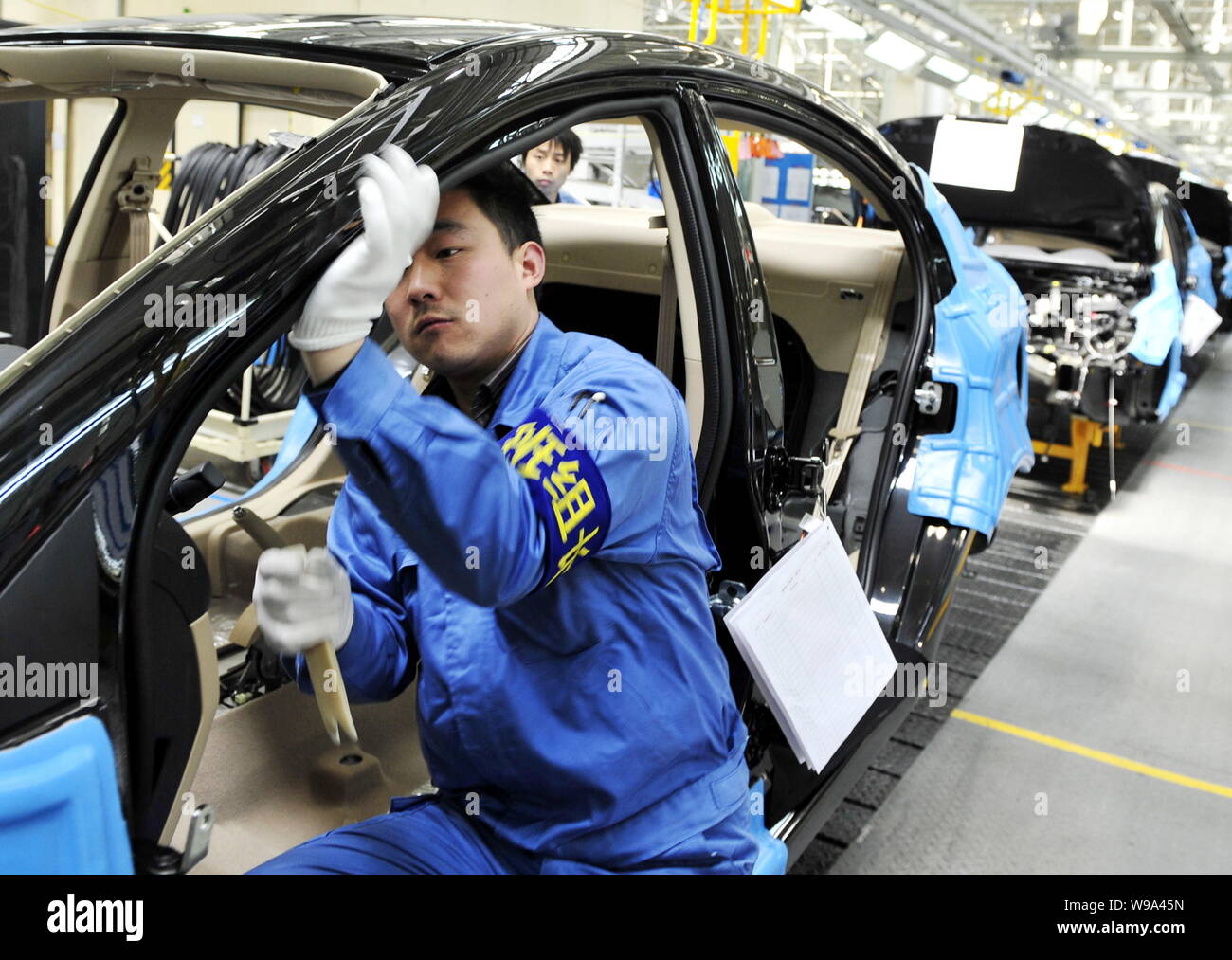 Chinese factory workers assemble Roewe 350 cars on the assembly line at