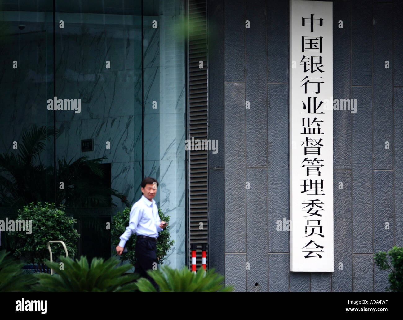 --FILE--A Chinese man walks past the China Banking Regulatory Commission in Beijing, China, 12 August 2010.   Chinas banking regulator may require the Stock Photo