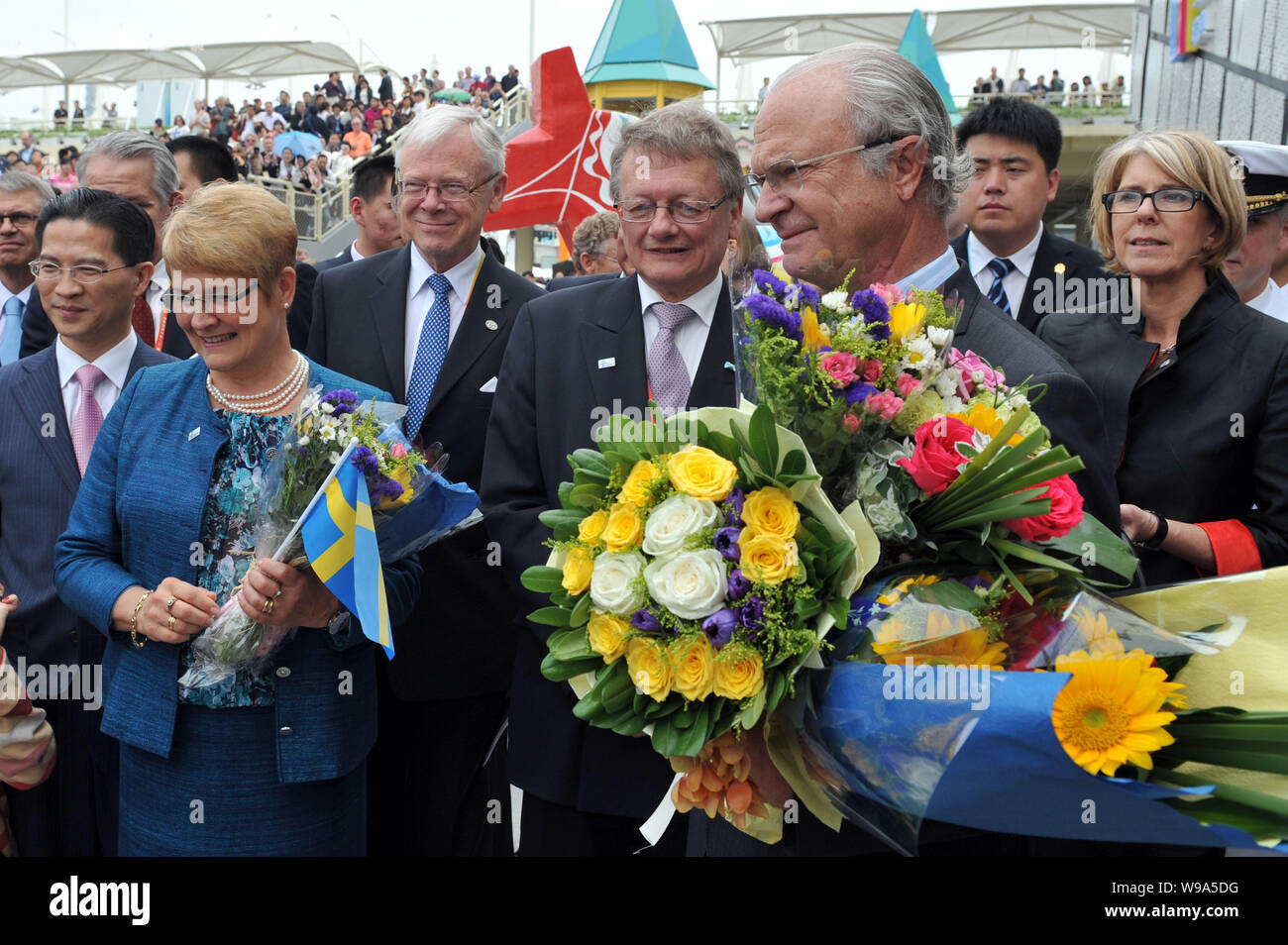 Swedish King Carl XVI Gustaf (F, R), Swedish Deputy Prime Minister Maud Olofsson (F, L) and followers stand next to the Sweden Pavilion in the Expo si Stock Photo