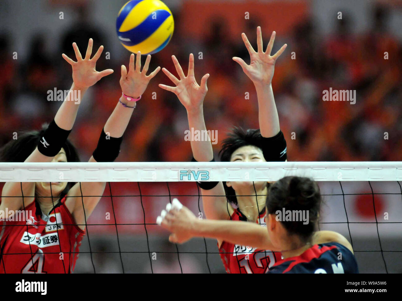 Kaori Inoue, back left, and Saori Kimura of Japan try to block a spike