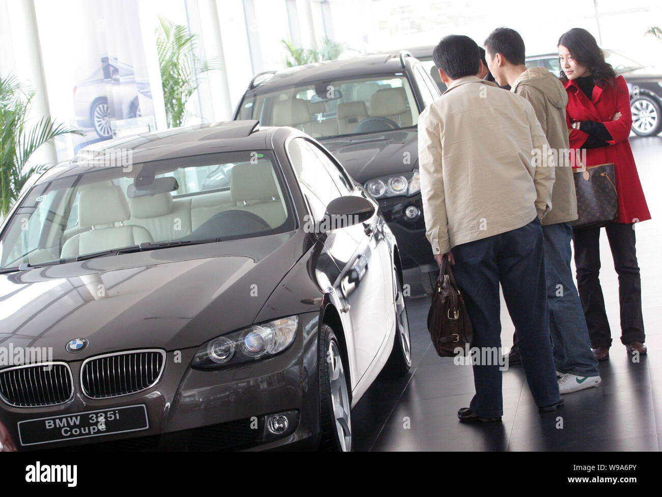 FILE-- Customers look at a BMW 325i Cooper at a BMW dealership in Shanghai,  China, December 3, 2009. BMW, the worlds biggest maker of premium cars  Stock Photo - Alamy