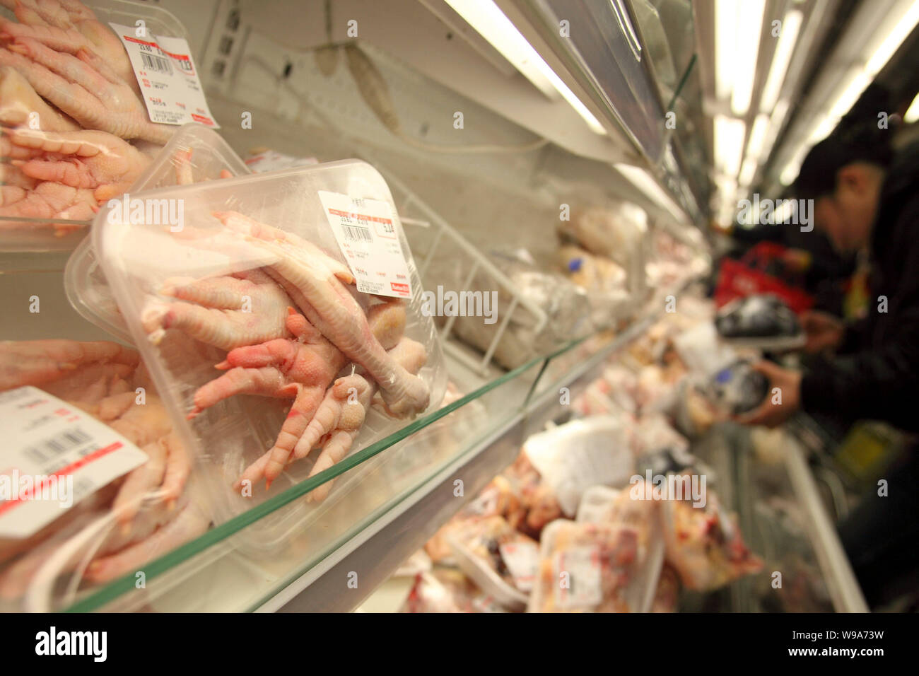 FILE--Chinese customers shop for chicken paws and other chicken products at  a supermarket in Shanghai, China, 8 February 2010. China will levy ant  Stock Photo - Alamy