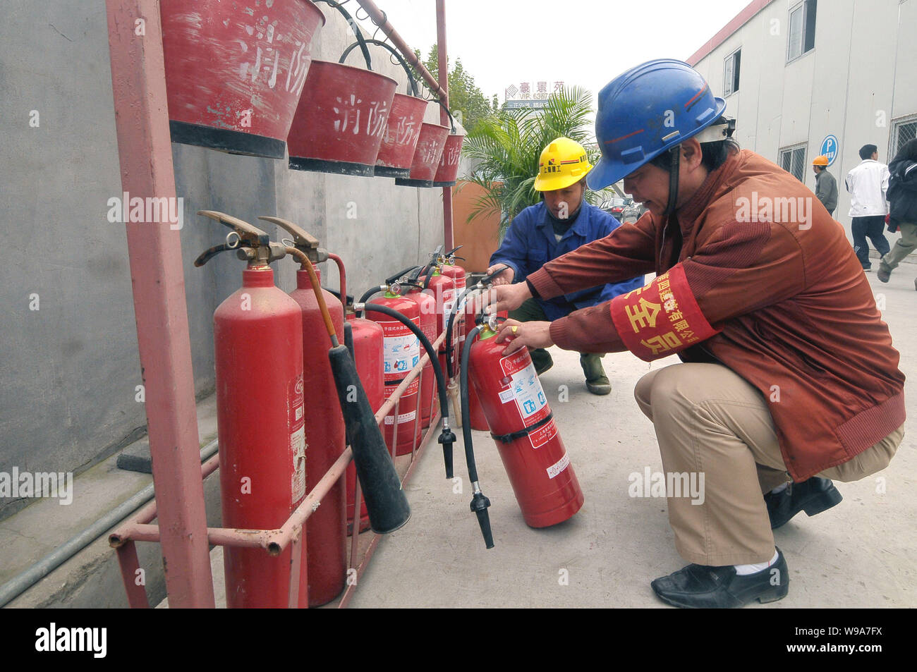 Chinese workers check the fire extinguishers and other firefighting