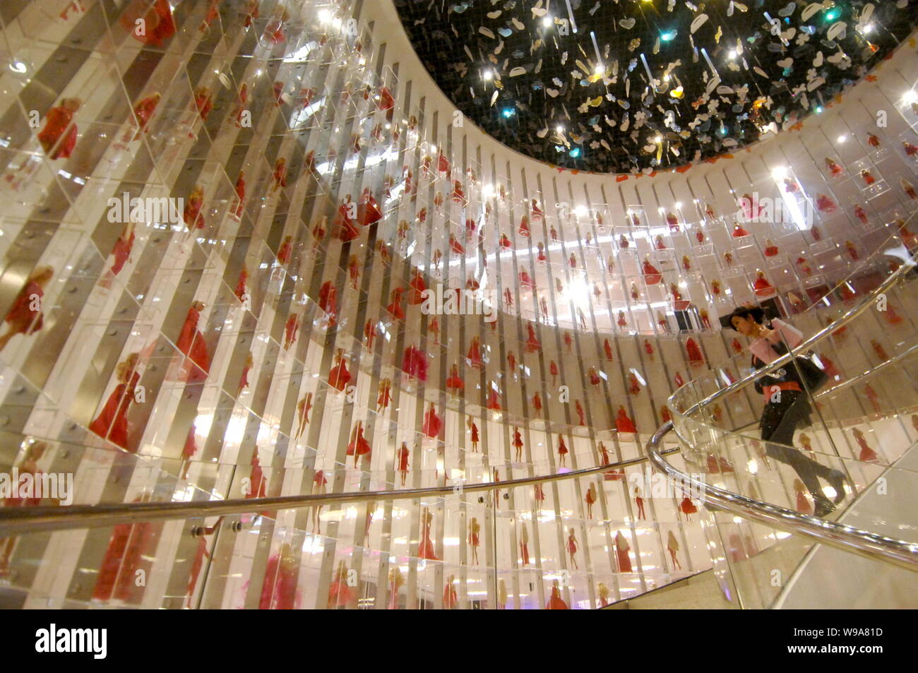 FILE A young Chinese woman walks past Barbie dolls on display at the Barbie flagship store in Shanghai China 6 March 2009. Barbie is reported t Stock Photo Alamy