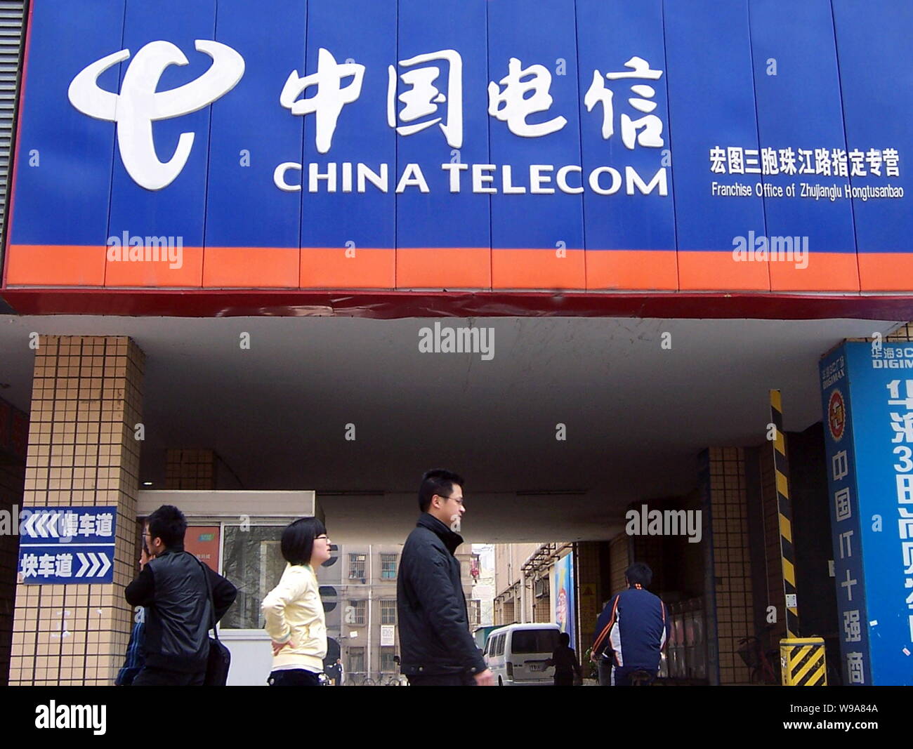 --FILE--Local Chinese residents walk past a branch of China Telecom in Nanjing city, east Chinas Jiangsu province, 17 April 2010.   China Telecom, the Stock Photo