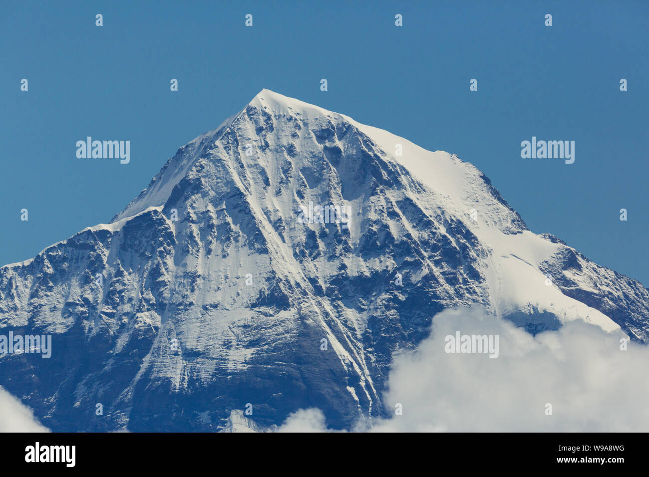 snowcapped Moench mountain summit in Switzerland, blue sky Stock Photo