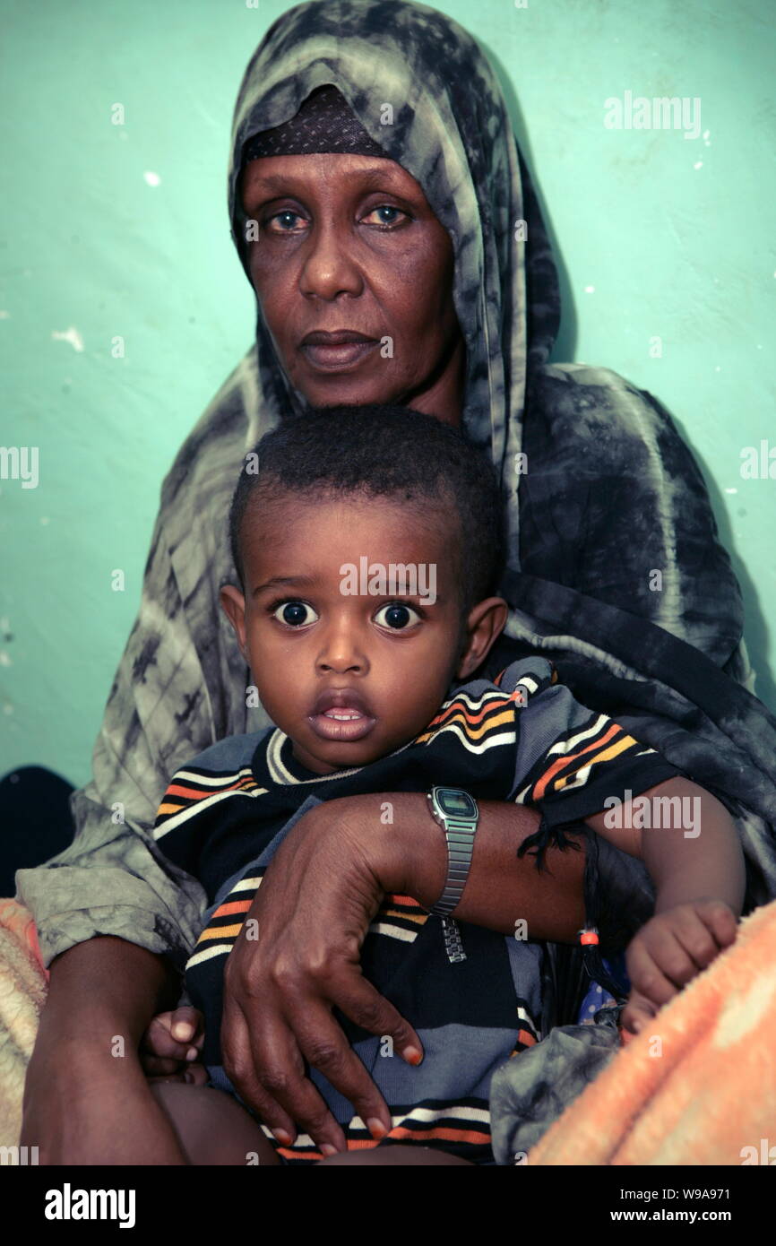 A Somali woman, mother of a mercenary, and his son pose for photos at their house in Puntland State, Somalia, 19 January 2009.   Two young Chinese jou Stock Photo