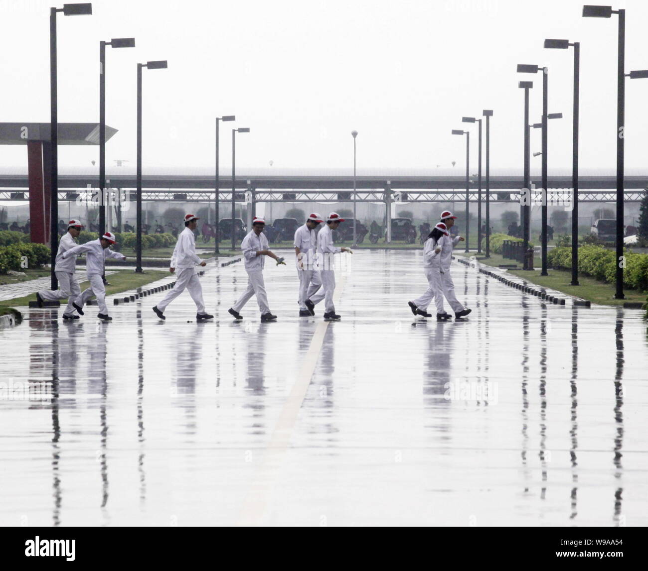 Chinese factory workers walk across the campus of an auto parts plant of Honda in Foshan city, south Chinas Guangdong province, 2 June 2010.   Chinese Stock Photo