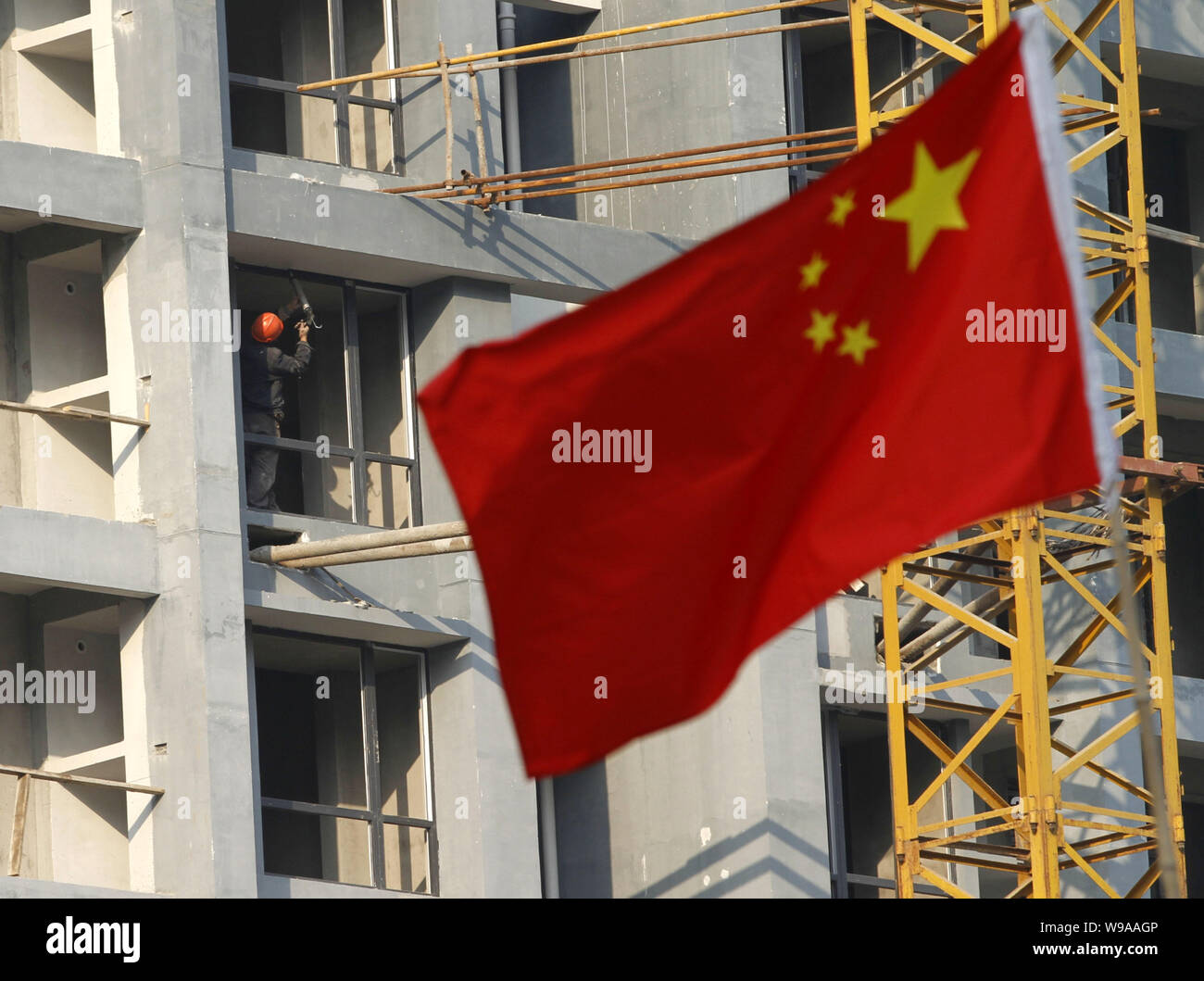 --FILE--A Chinese flag flutters in front of a residential apartment building under construction in Nanjing city, east Chinas Jiangsu province, 31 Octo Stock Photo