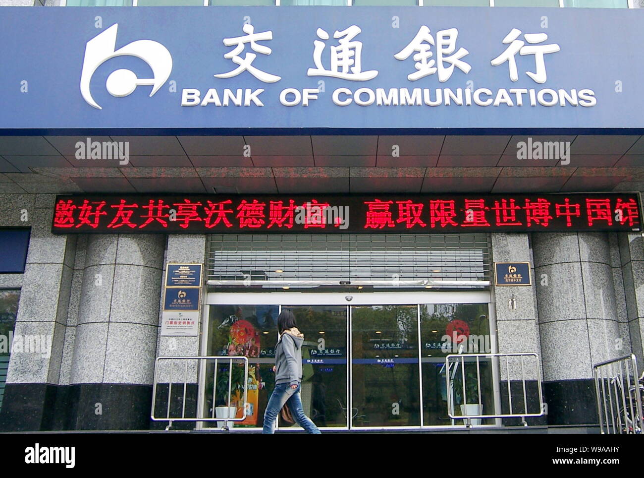 --FILE--A Chinese woman walks past a branch of Bank of Communications (BoCom) in Nanjing city, east Chinas Jiangsu province, 17 April 2010.   Bank of Stock Photo
