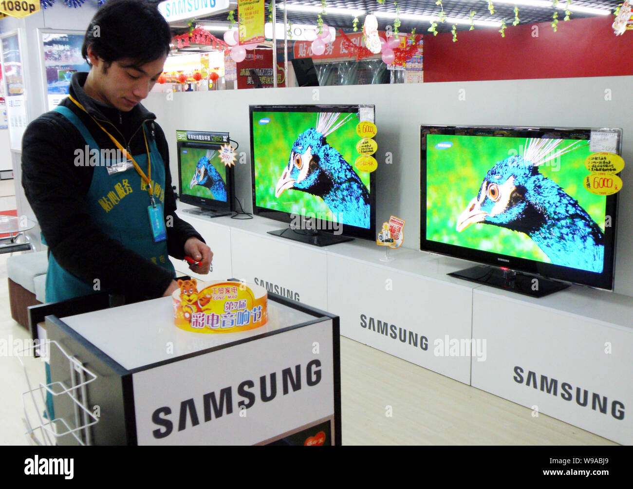 FILEA Chinese staff stands next to Samsung LCD televisions for sale