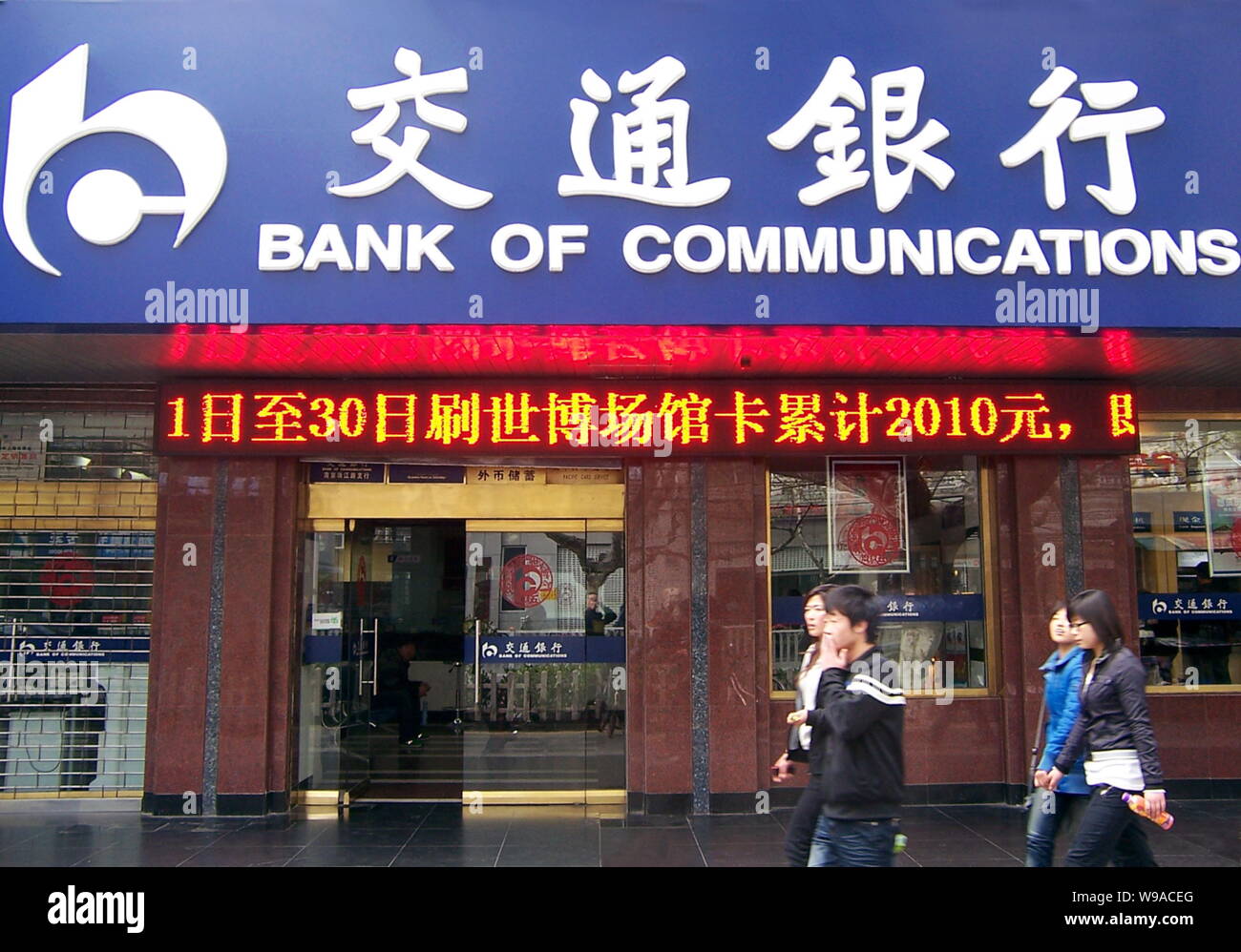 --FILE--Local Chinese residents walk past a branch of Bank of Communications (BoCom) in Nanjing city, east Chinas Jiangsu province, 17 April 2010.   B Stock Photo