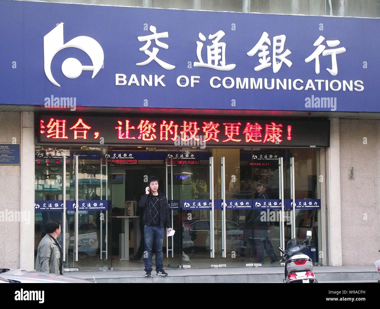 A Chinese man is seen outside a branch of Bank of Communications in Nanjing city, east Chinas Jiangsu Province, November 8, 2010.   China has increase Stock Photo