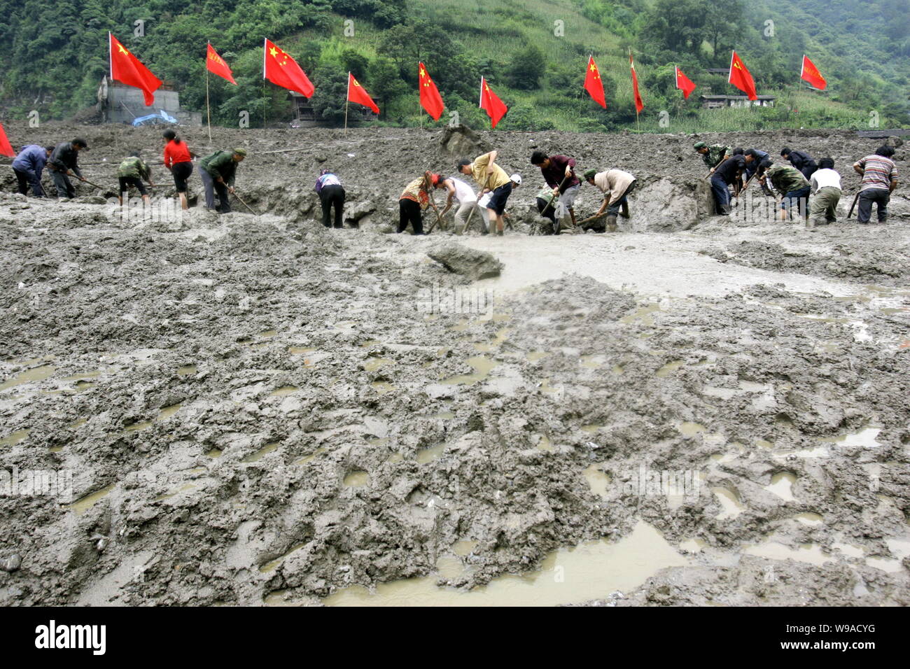 Chinese rescuers try to clean up the mud in the aftermath of the mudslides in Litoudi village, Puladi township, Gongshan county, Nujiang Lisu Autonomo Stock Photo