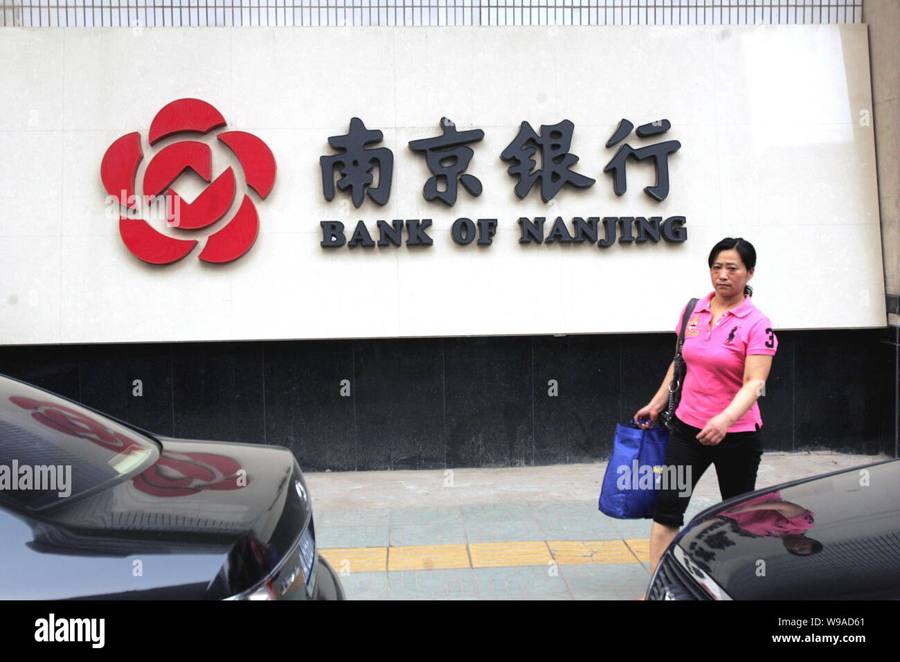 A Chinesen woman walks past a name board of Bank of Nanjing in Nanjing city, east Chinas Jiangsu Province, June 13, 2010.   Chinas securities regulato Stock Photo