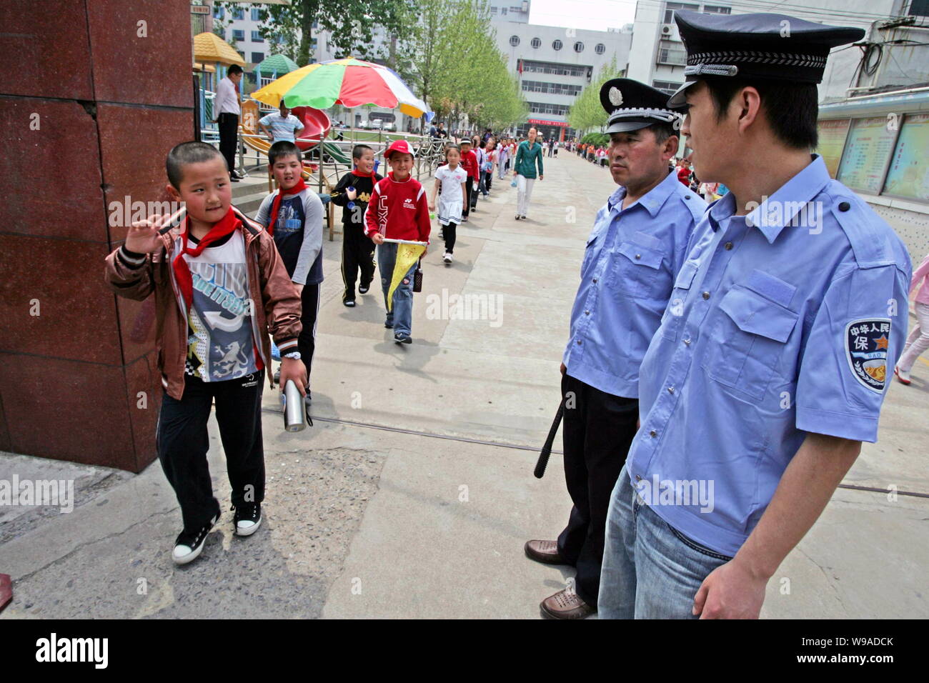 Chinese security guards stand guard at the entrance of a primary school