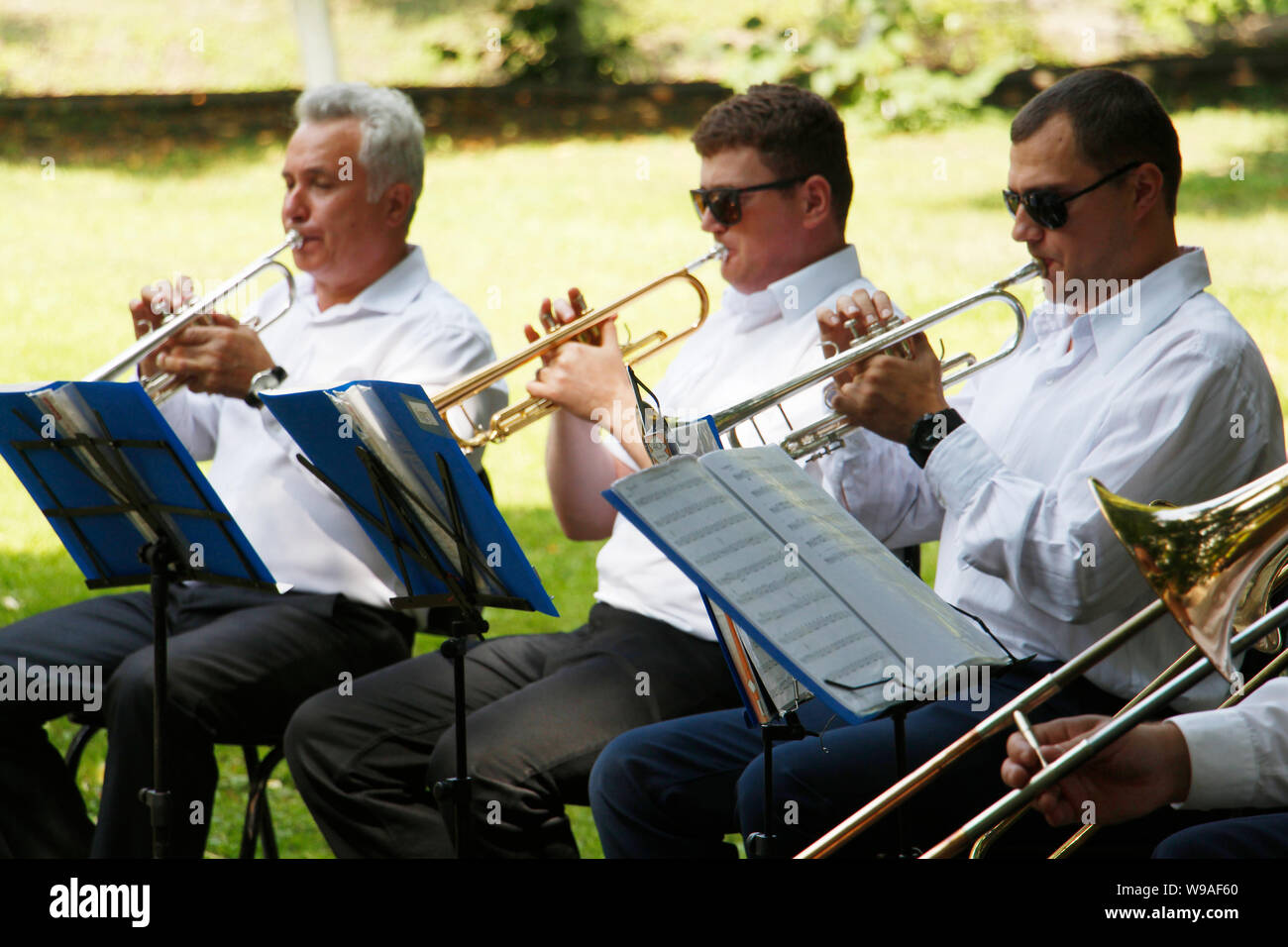 Moscow, RF, 27.07.2019 Brass band. Many people play trumpets in the park. Sunny day. Nature Old musicians with trumpets Stock Photo