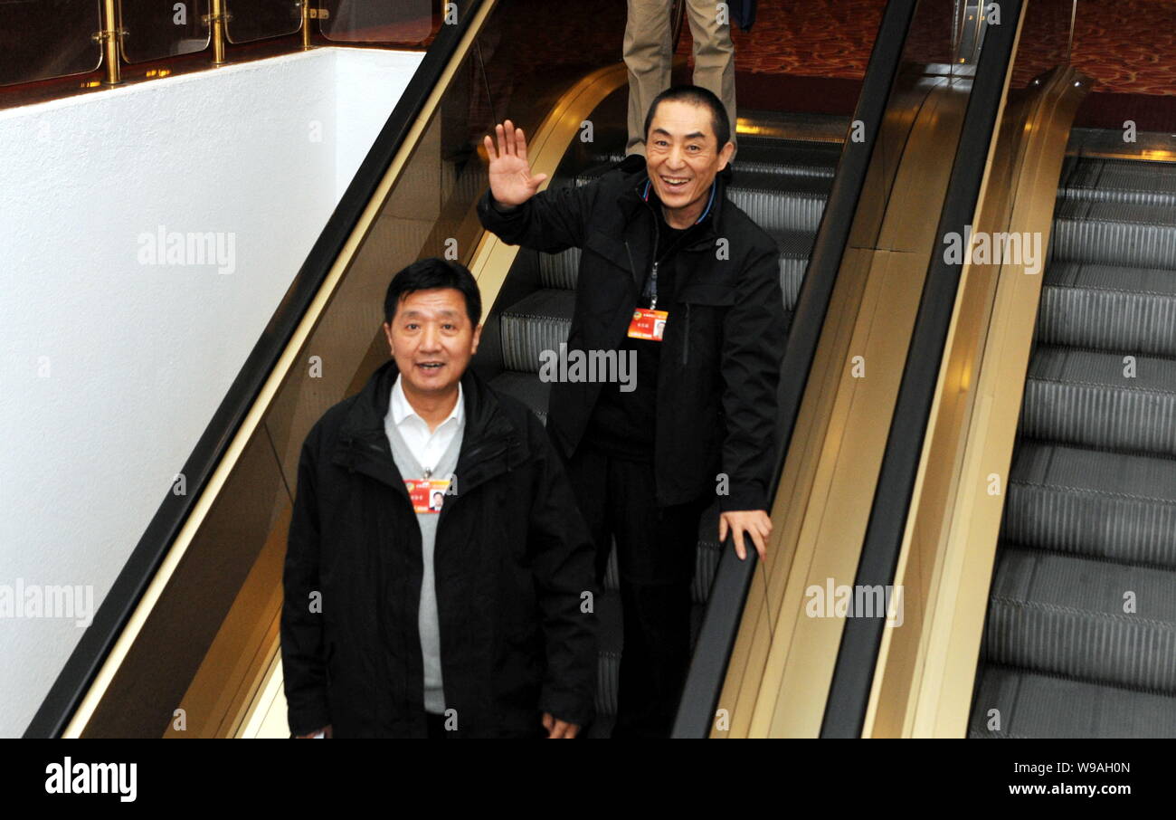 Chinese film directors Zhang Yimou, right, waves to reporters next to a delegate of CPPCC (Chinese Peoples Political Consultative Conference), the cou Stock Photo