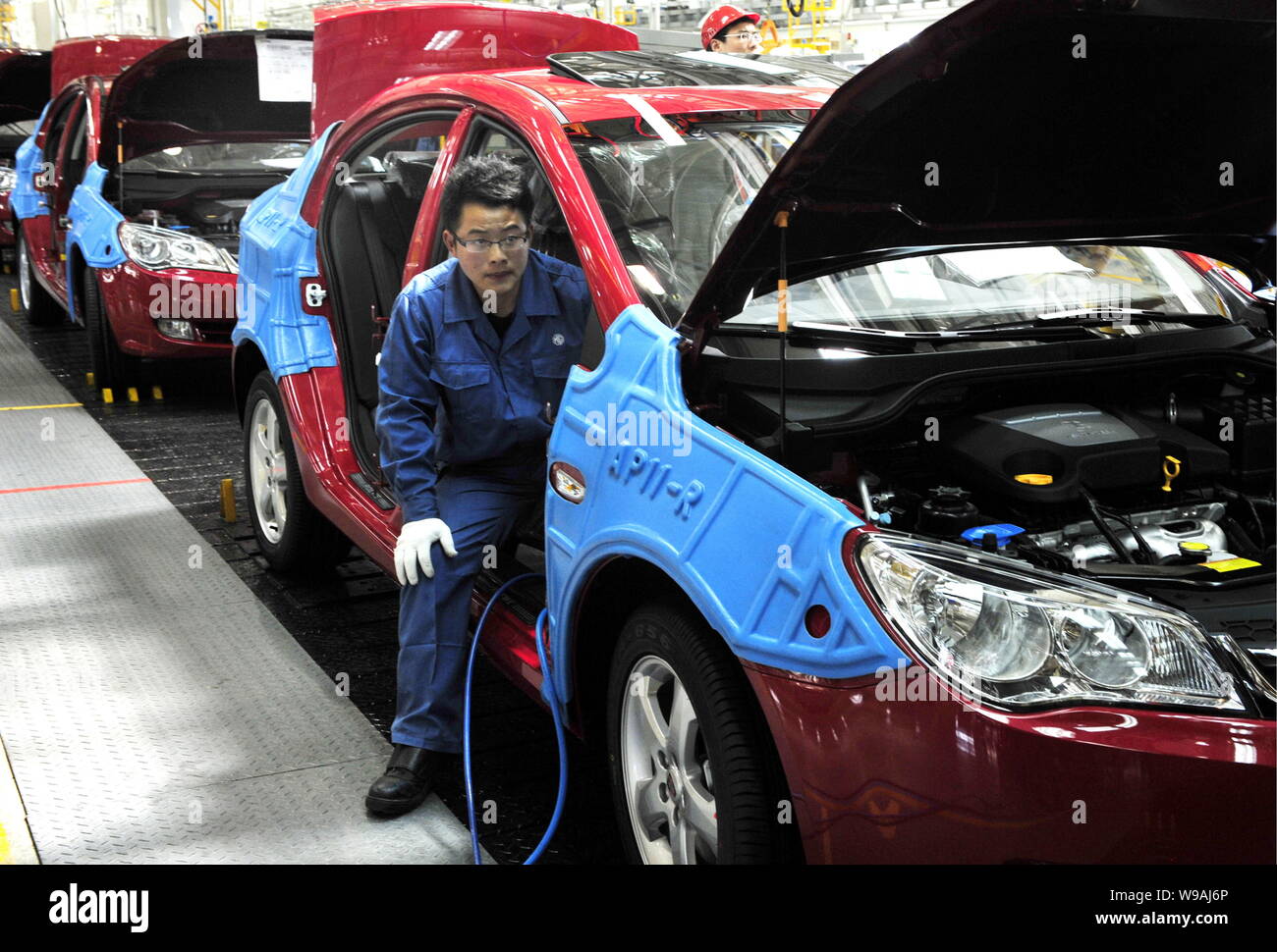 Chinese factory workers assemble Roewe 350 cars on the assembly line at ...