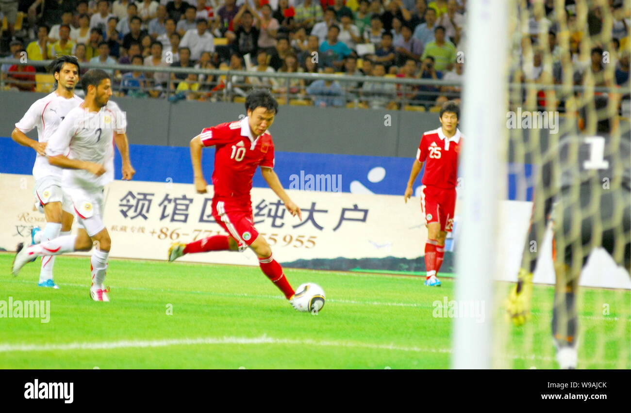 Chinas Deng Zhuoxiang, center, dribbles next to players of Bahrain during a friendly soccer match in Nanning city, south Chinas Guangxi Zhuang Autonom Stock Photo
